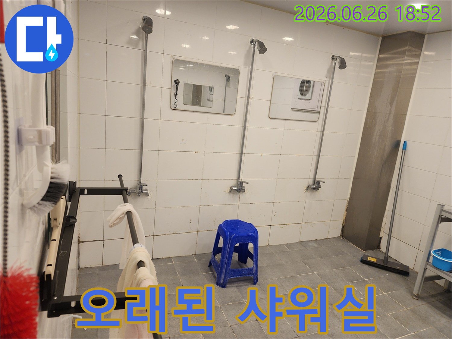 오래된 샤워실의-전체적인 모습-타일-배관-거울-그리고-청색 의자가-보입니다