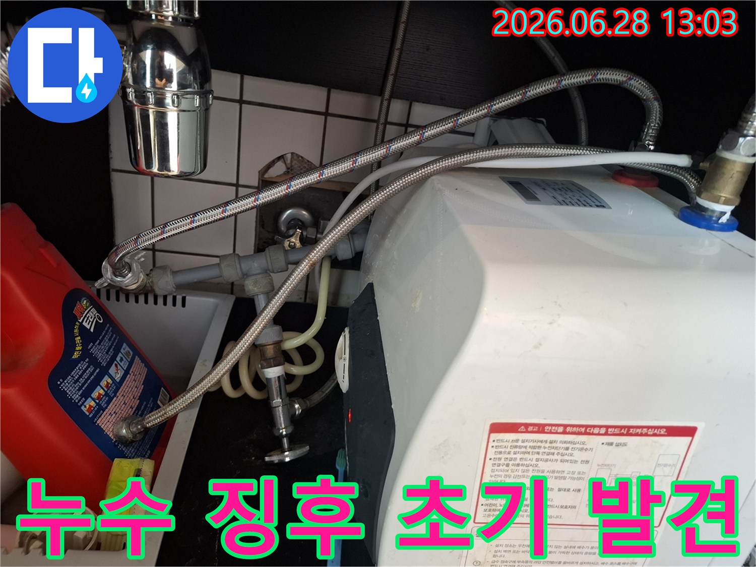 온수기-배관-연결부에서-미세한-누수-징후를-초기에-발견하기-위해-전문가가-세심하게-살피는-모습입니다.