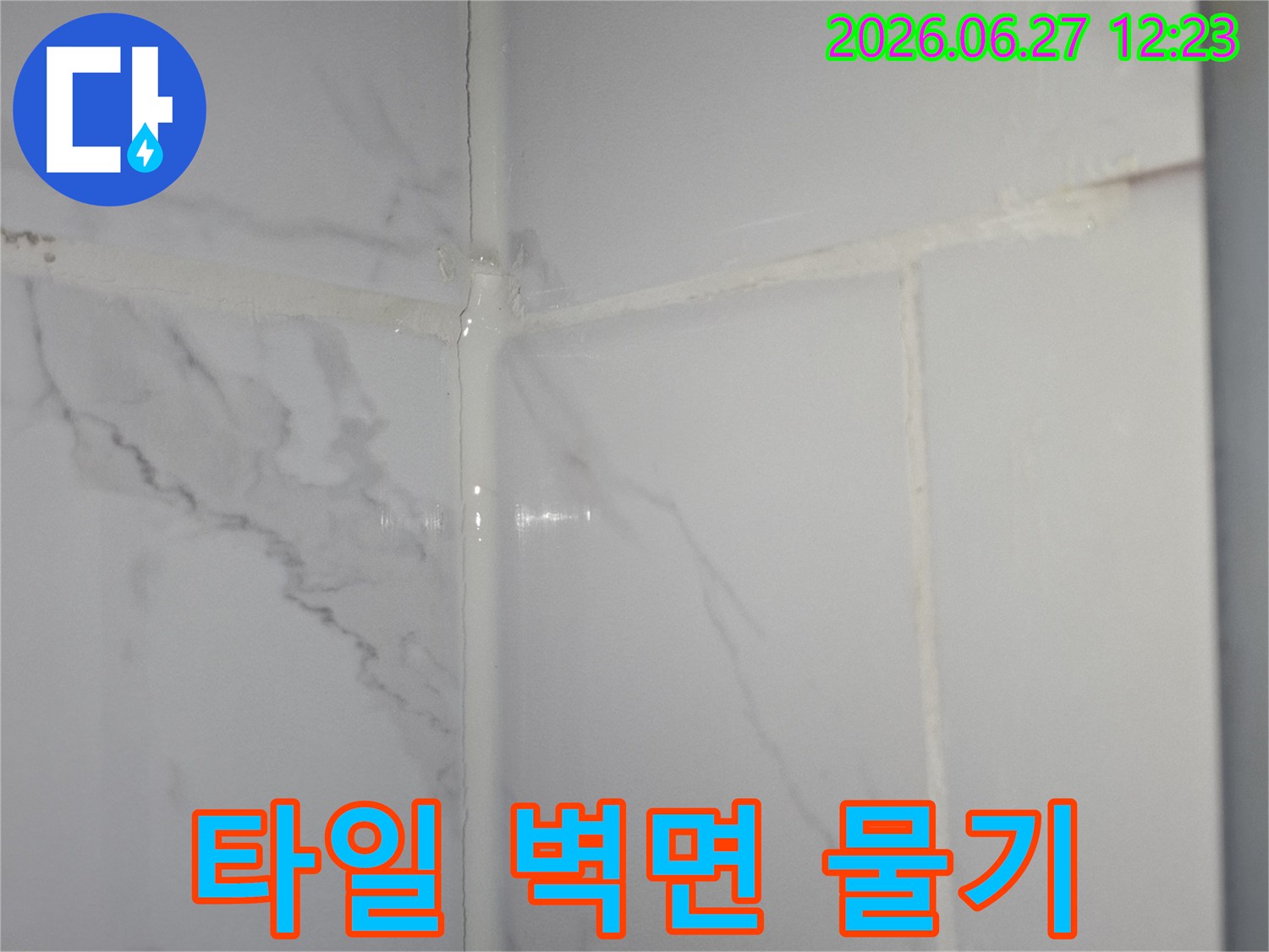 타일과 벽면이 만나는 경계에서-물기가 감지된 모습을 보여주는-누수 의심 지점