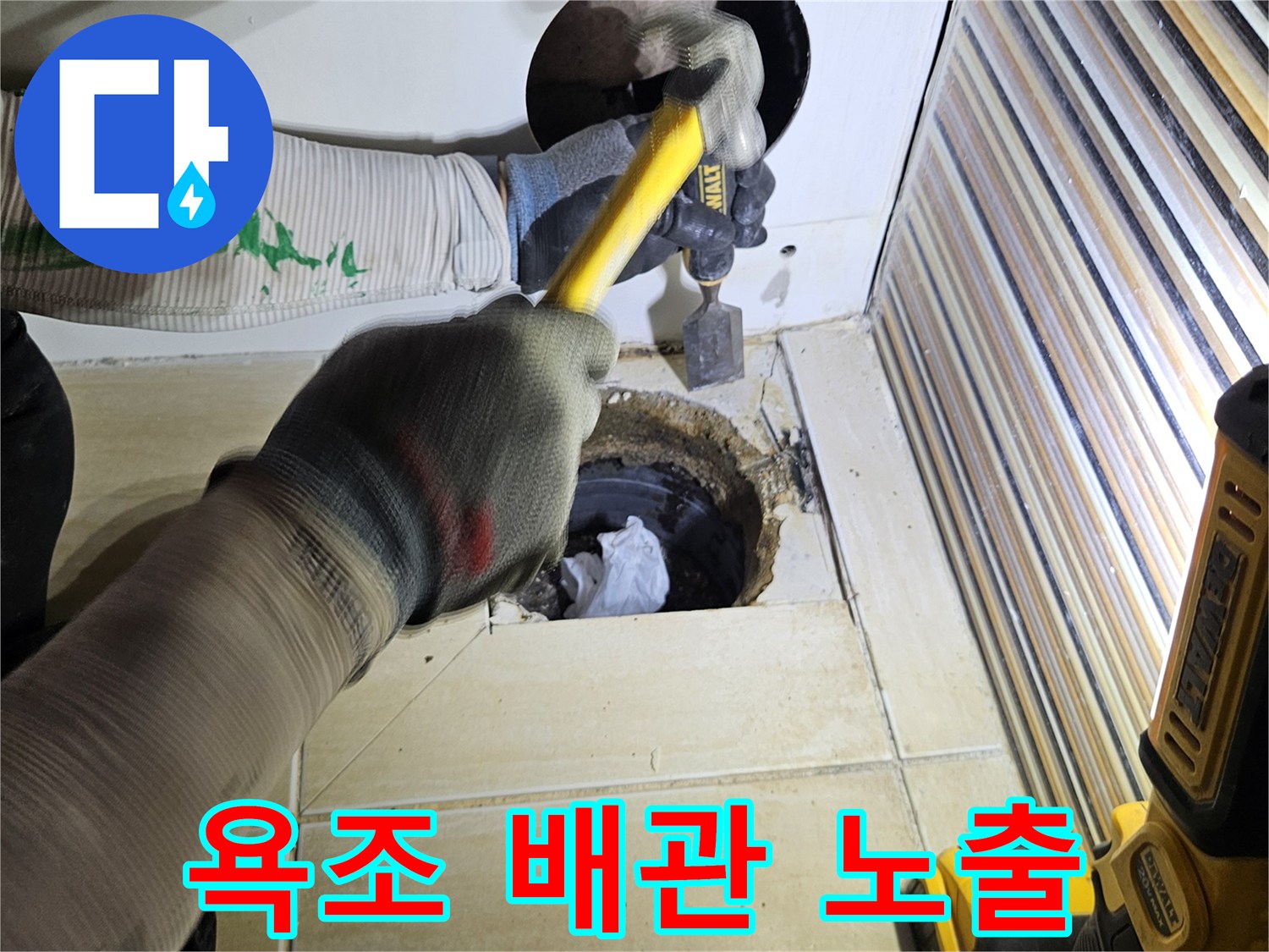 망치로 타일을 제거하여 욕조 내부 배관을 확인하는 공사 과정