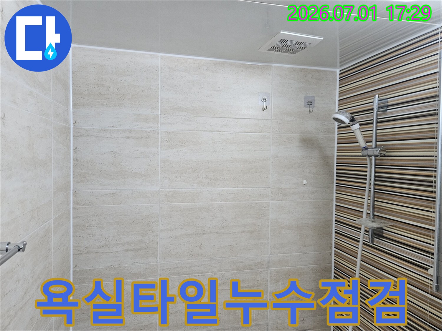 이 이미지는-울산 반구동 욕실의-누수 점검 후-깔끔하게 정리된-타일과 샤워기-환풍기 모습을-보여줍니다.