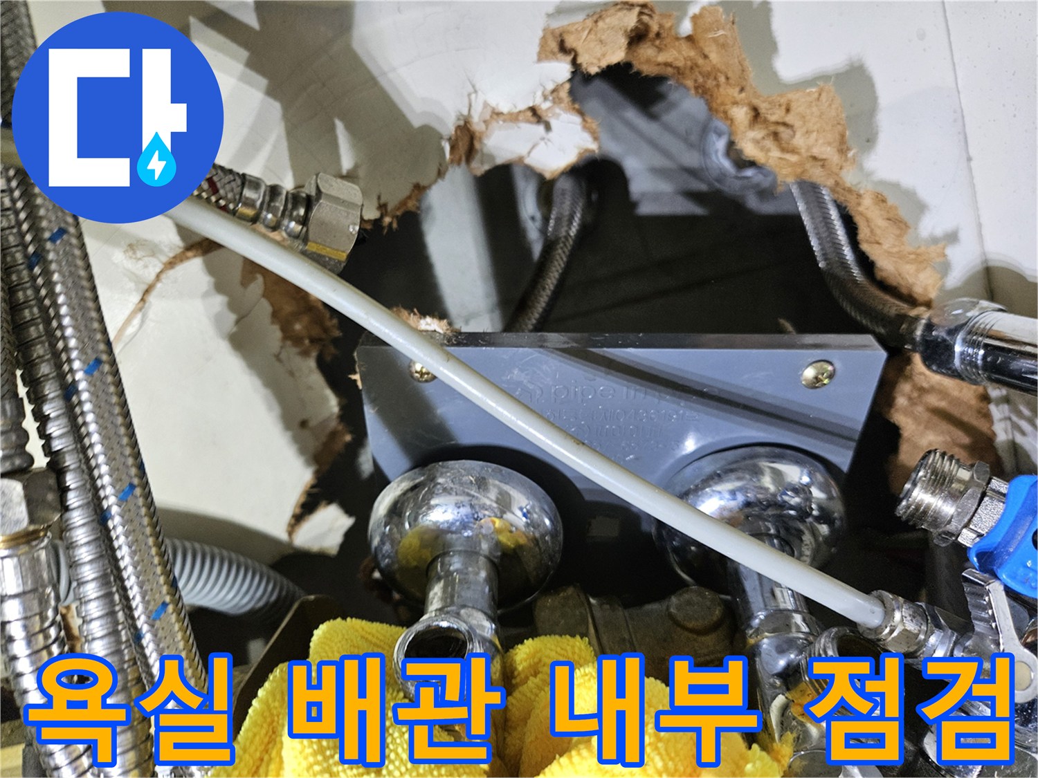 타공된 욕조 틈새로 보이는 금속 배관과 연결 부위