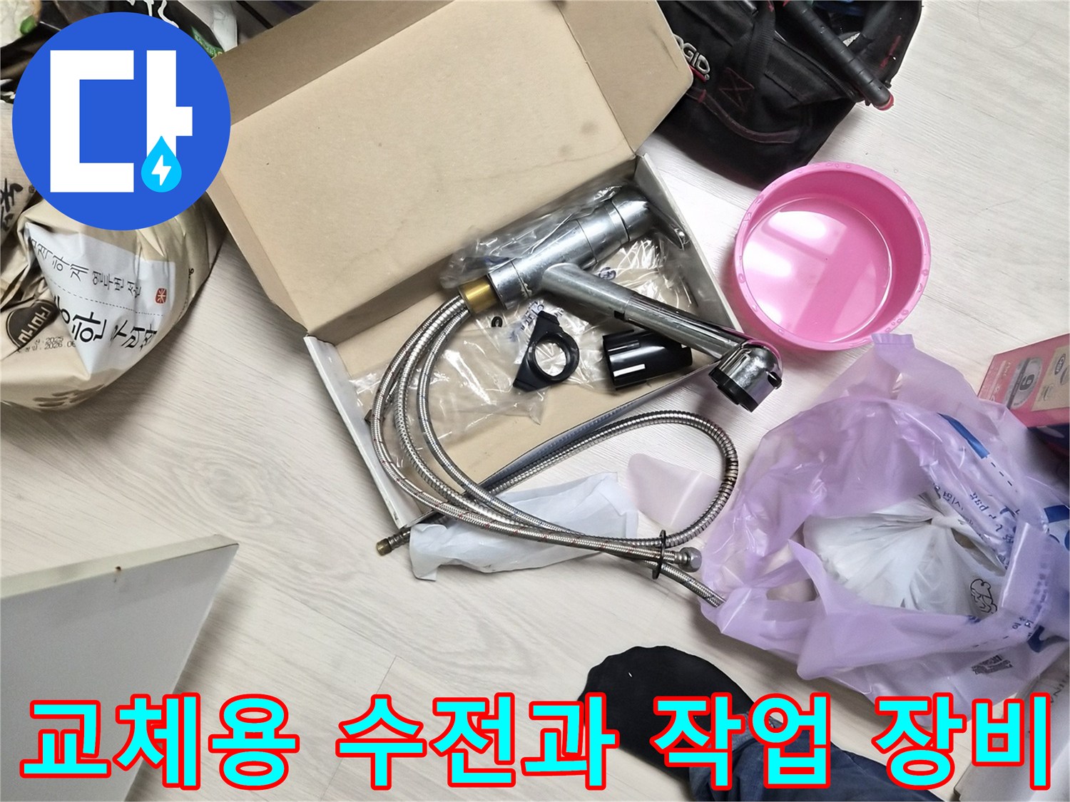 바닥에 놓인 새 싱크대 수전과 렌치 등 작업 도구 세트