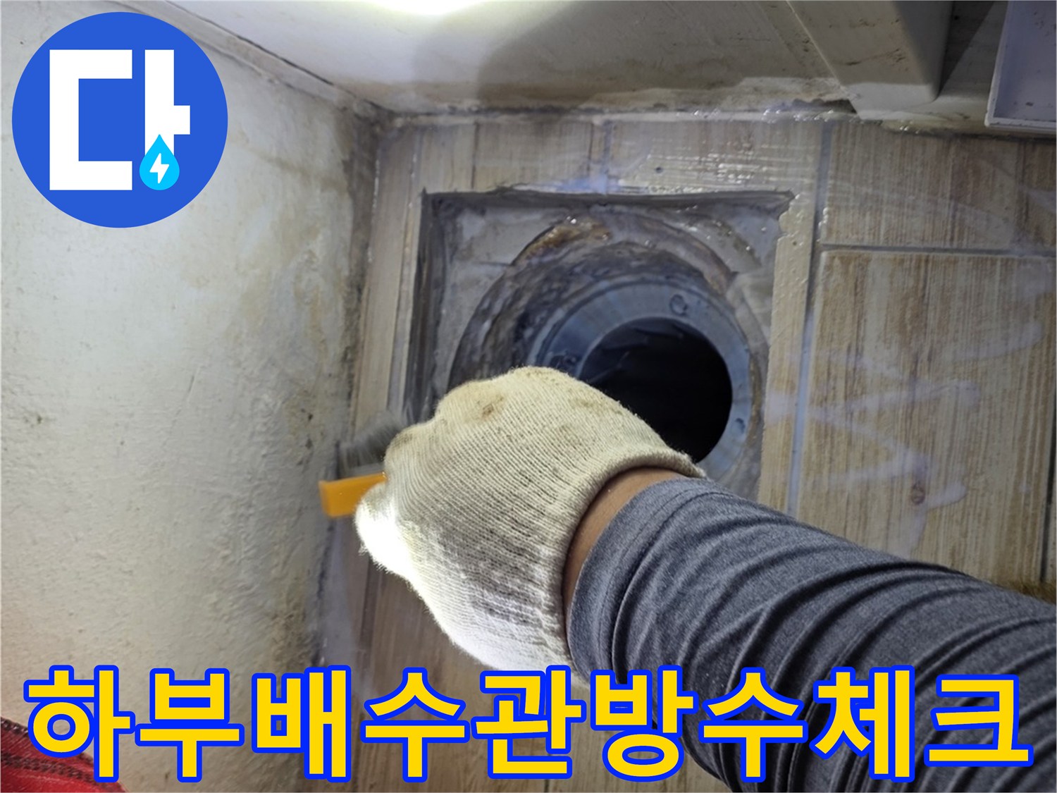 밝은 조명을 비추며 세탁실 배출구 주변의 미세한 균열을 확인하는 점검 과정