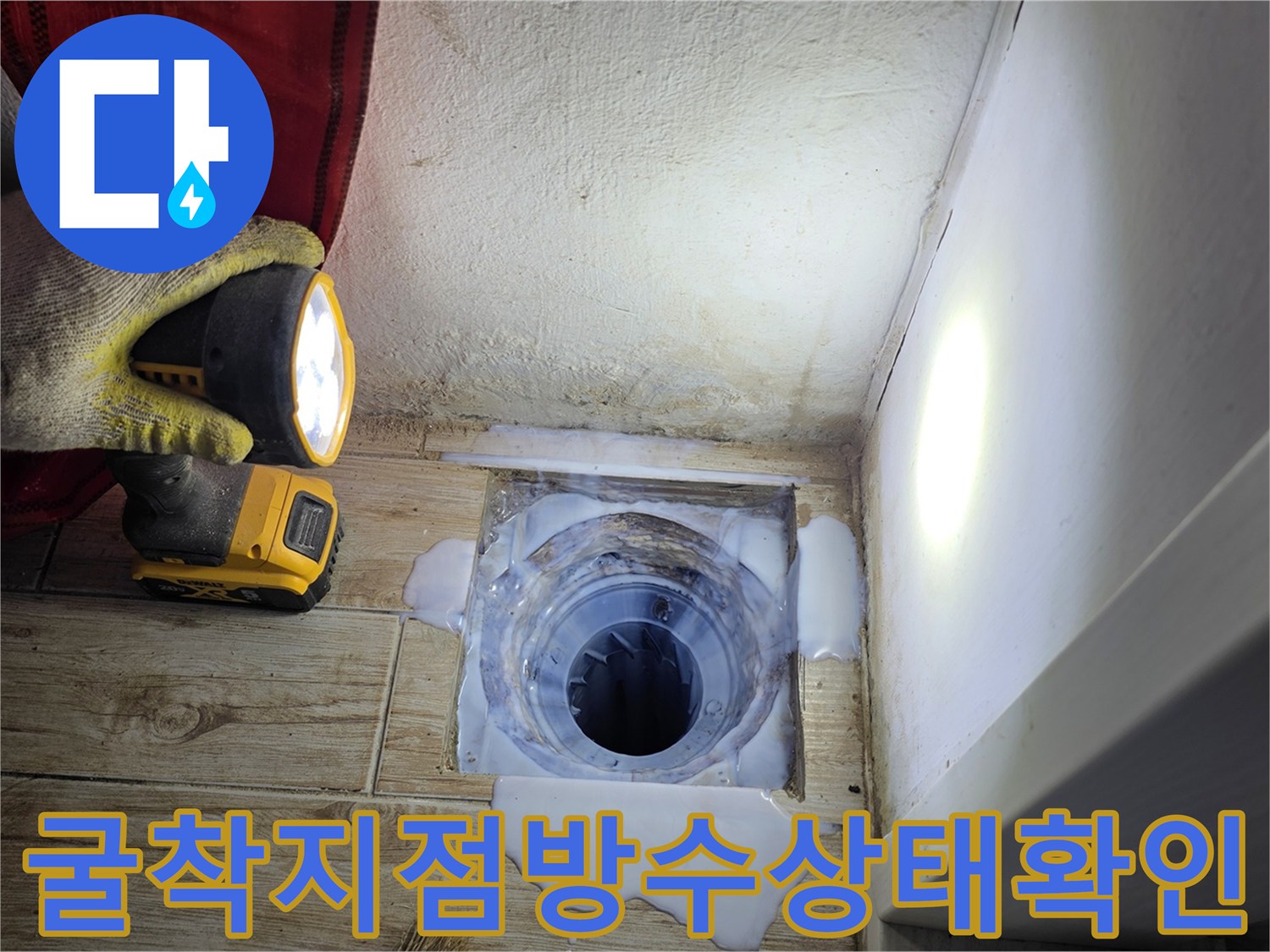 세탁실 바닥 굴착 후 노출된 배수구 주변 방수 상태 확인 장면