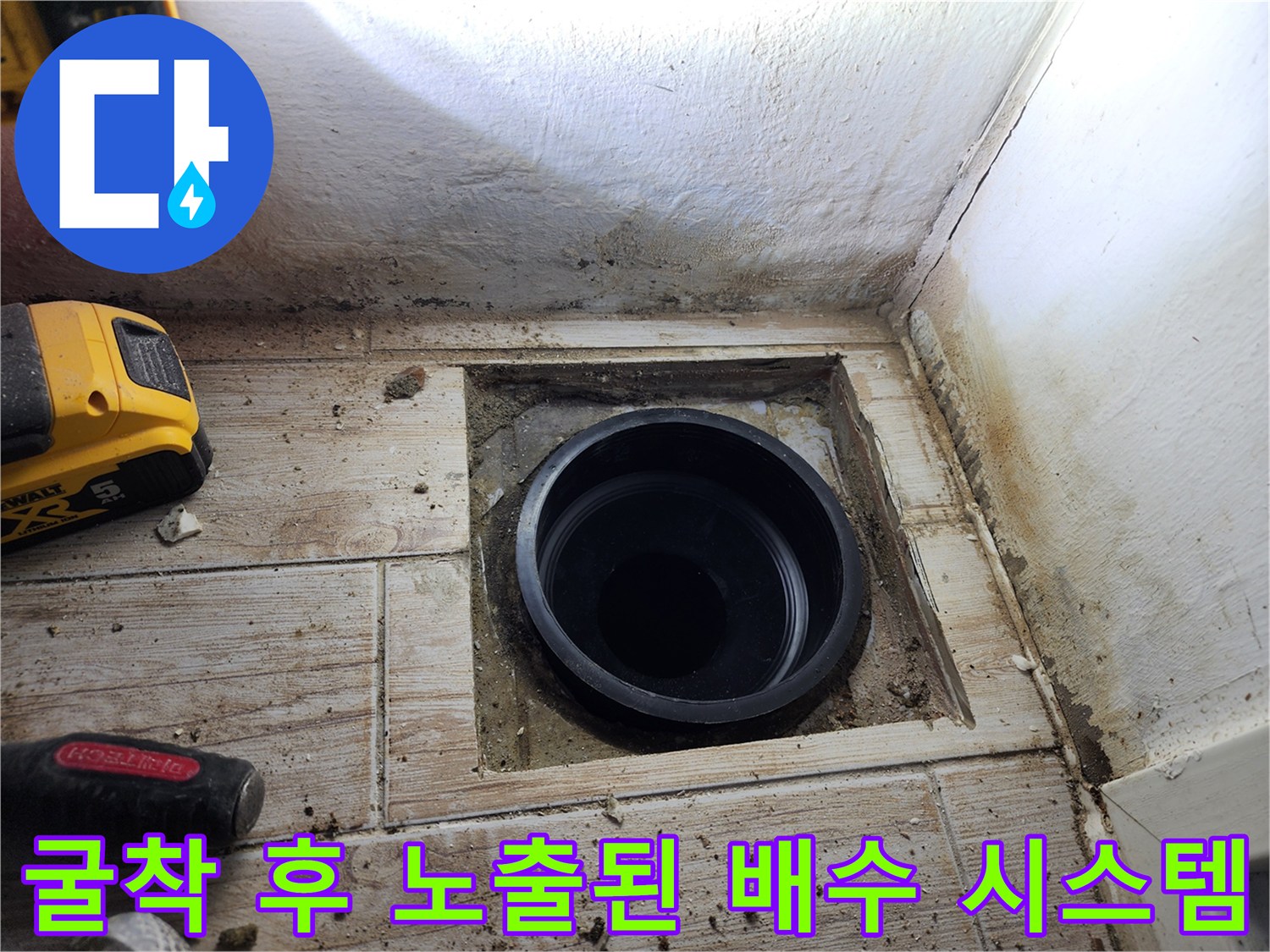 세탁실 바닥을 뜯어내고 드러난 검은색 플라스틱 배수 파이프