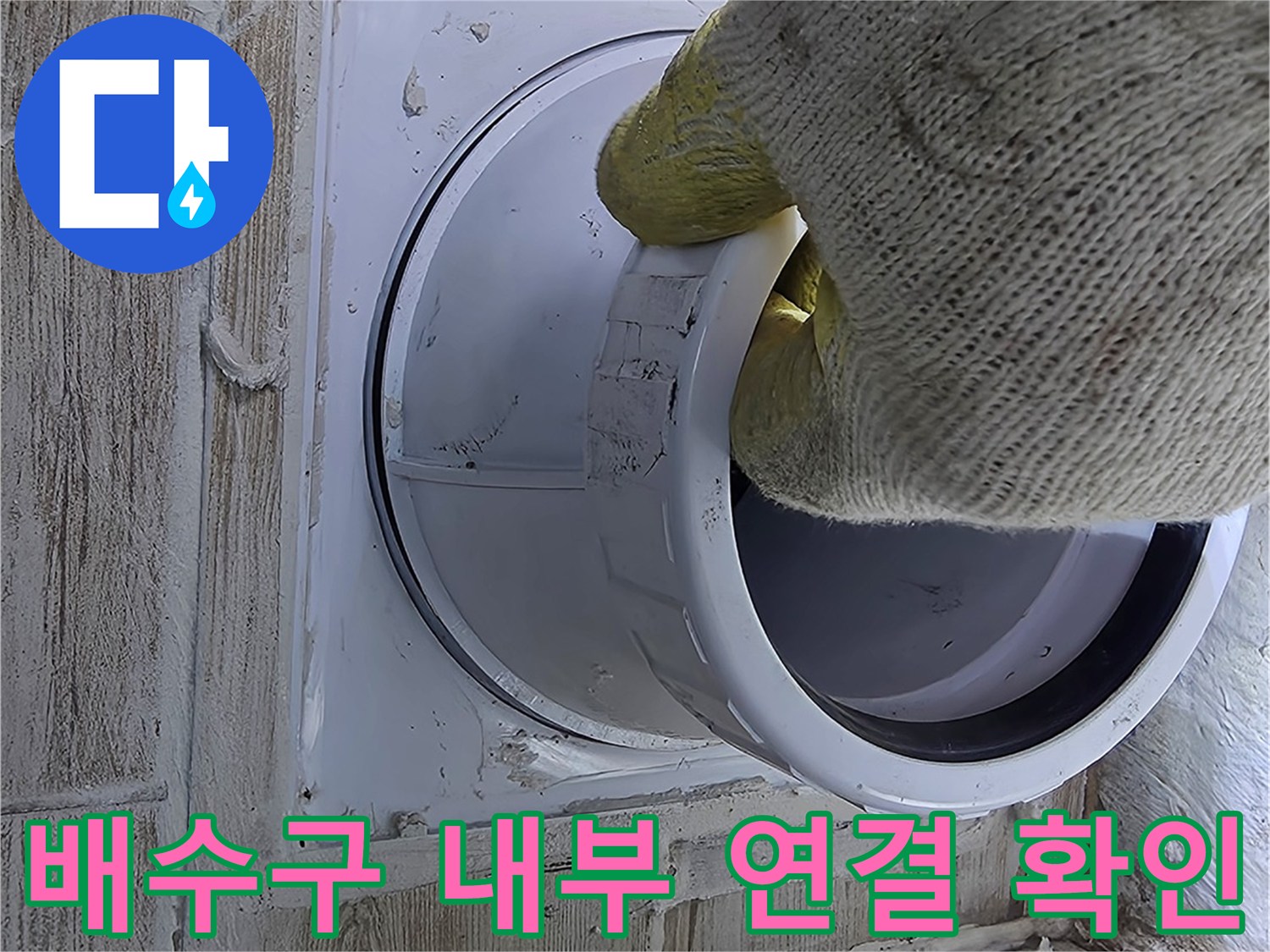 장갑을 낀 손으로 배수구 안쪽 파이프 상태를 점검하는 모습