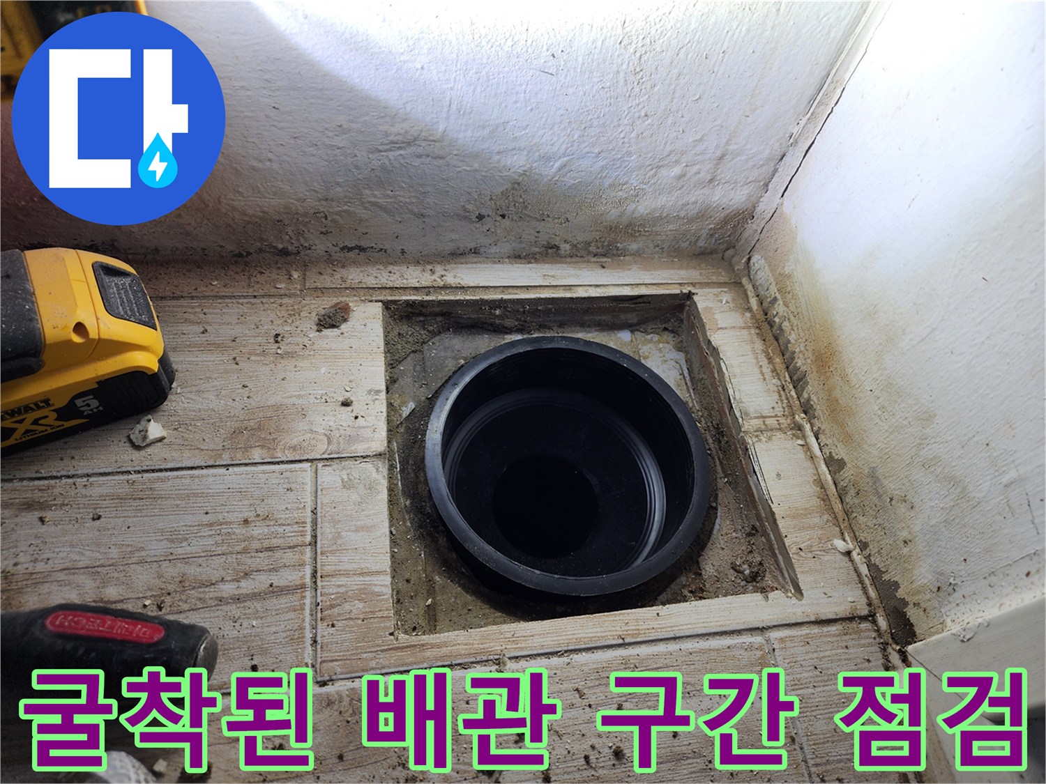타일 제거 후 드러난 배수구 안쪽의 검은색 배출 파이프와 주변부 상태 촬영