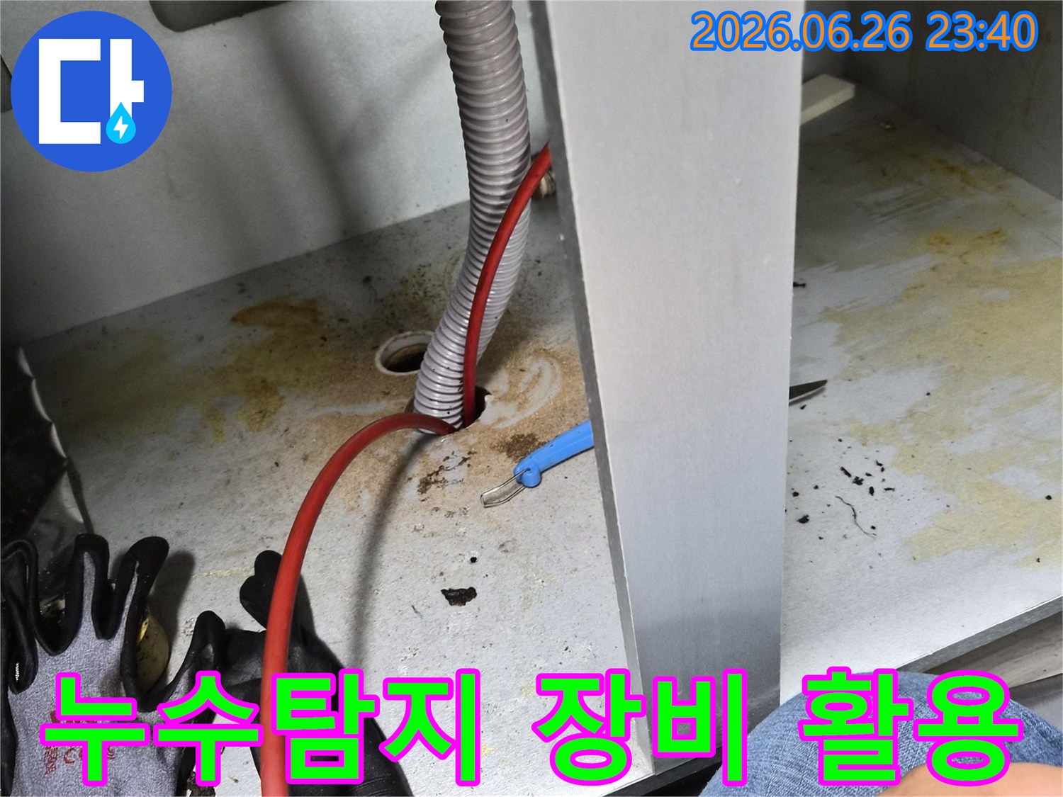 누수 흔적이-있는-배관 주변에서-전문가가-탐지 장비를-활용하여-정밀하게-누수 지점을-찾는-모습입니다.