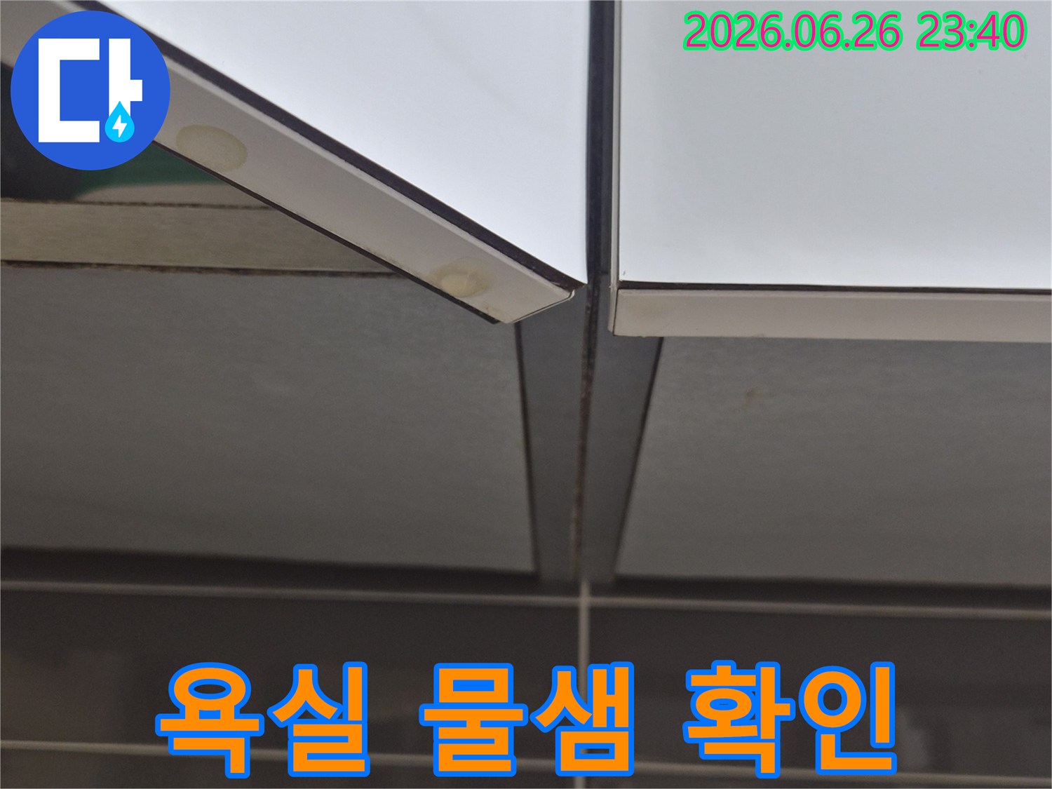 욕실-거울-하단과-타일-경계면에서-발견된-물기-흔적과-변색을-보여주는-사진
