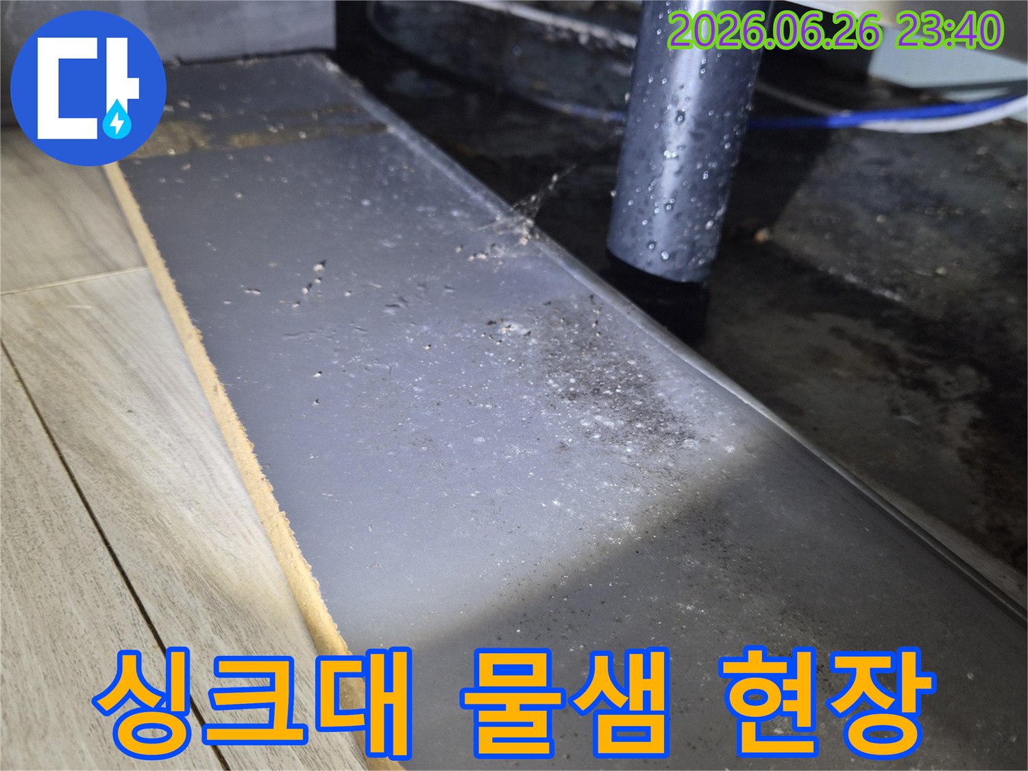 주방 싱크대 하부의 배수관에서 물이 새어-주변에 물기가 맺힌 모습을 보여주는 사진