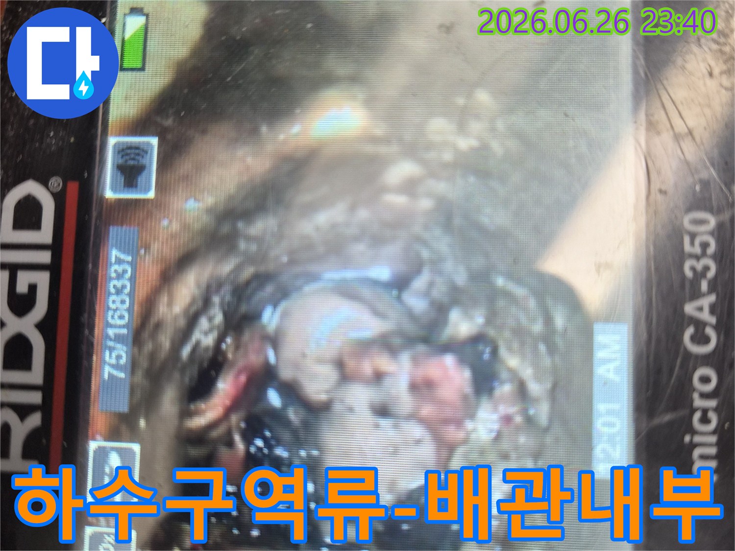 하수구 역류의 원인을 찾기 위해-내시경 카메라로 촬영한-배관 내부의-심각한 이물질과-손상 상태를 보여주는 이미지입니다.