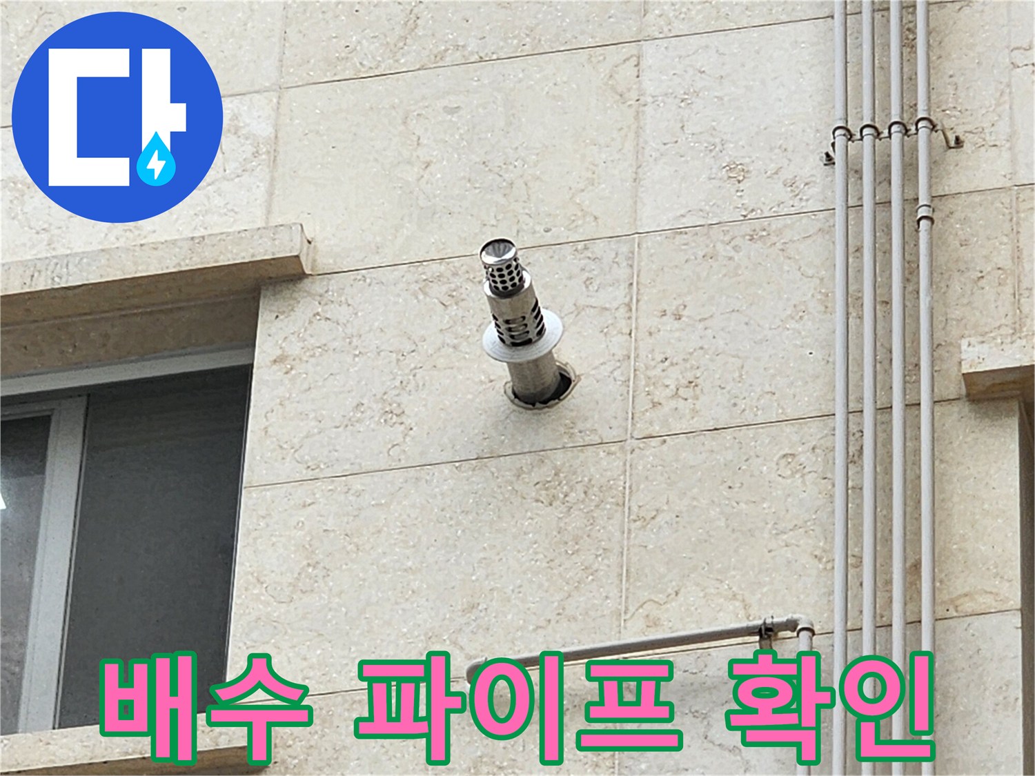 외벽에 돌출된 금속 배관과 수직으로 내려오는 관의 모습
