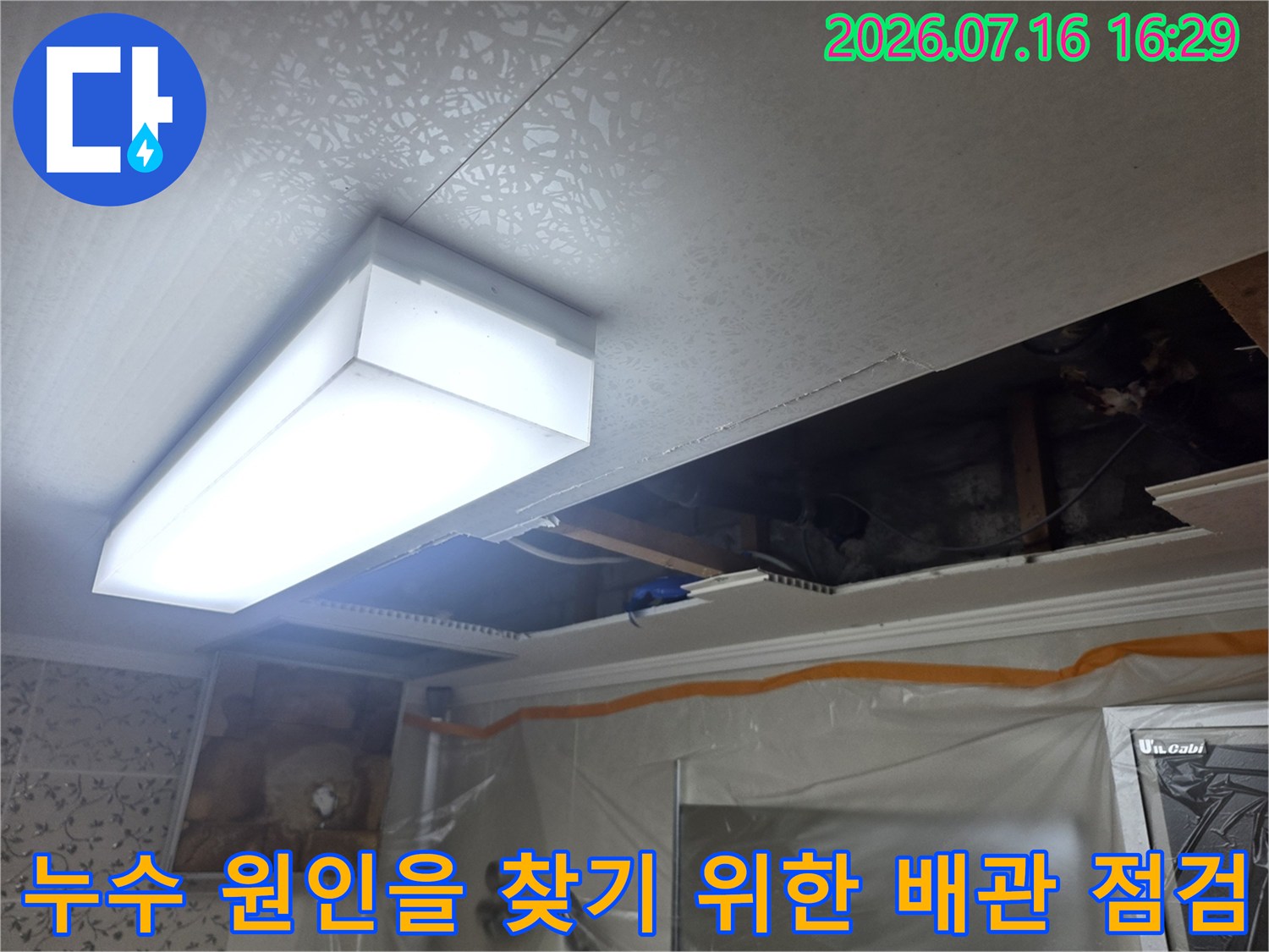 화장실 천장 내부 공간에서 노출된 배관과 구조물을 확인하는 모습