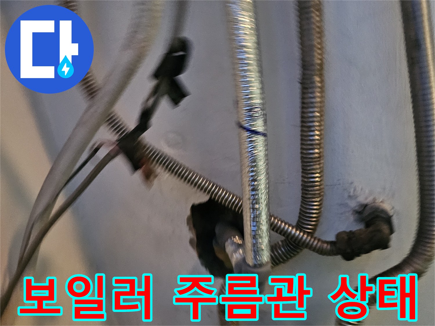 보일러 하단의 금속 재질 주름관과 배관 연결 부위 모습