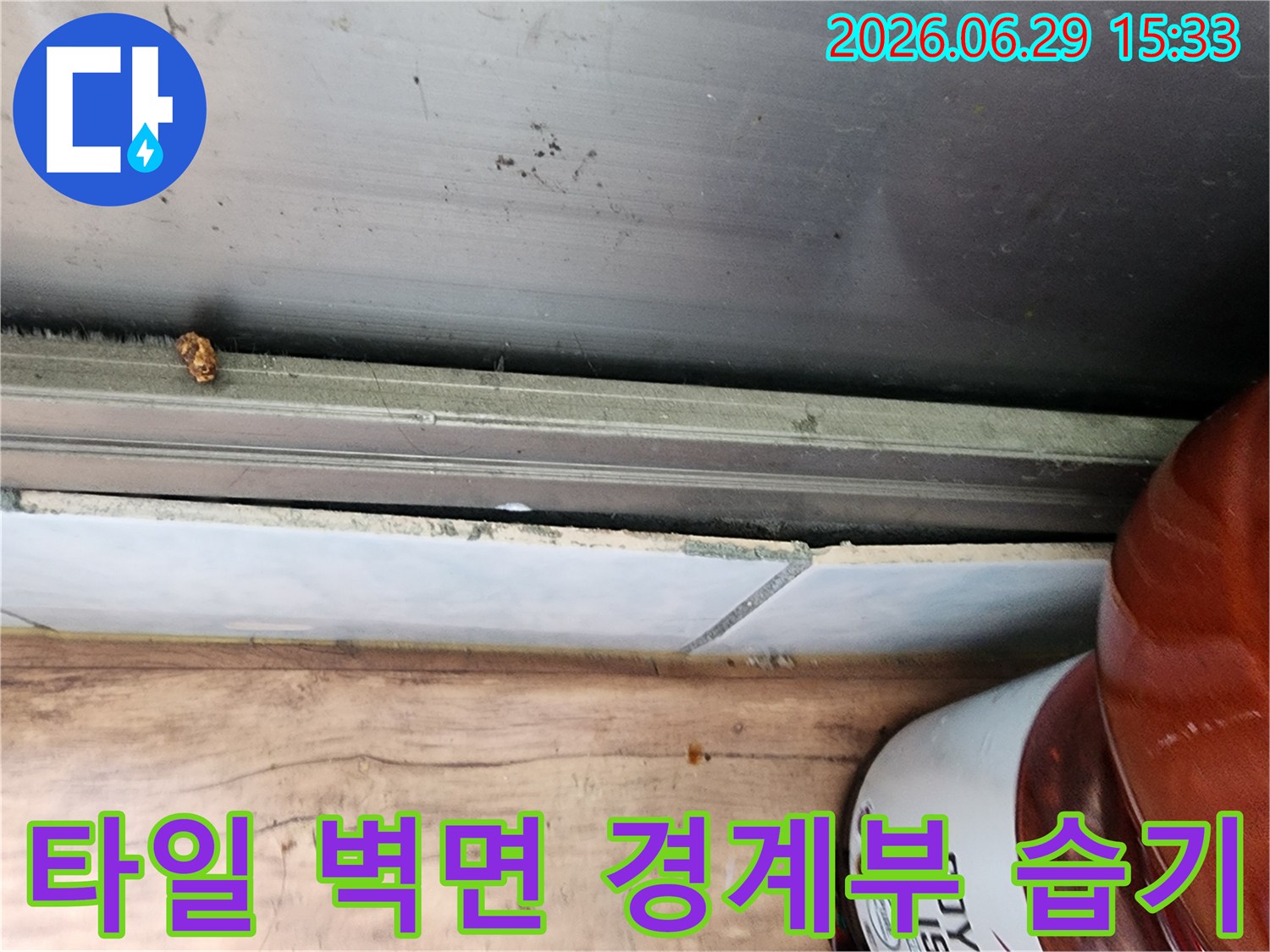 정왕동 대림아파트 누수 현장에서-타일과 벽면 경계부에서 확인된 습기 흔적을 상세히 보여주는 사진입니다