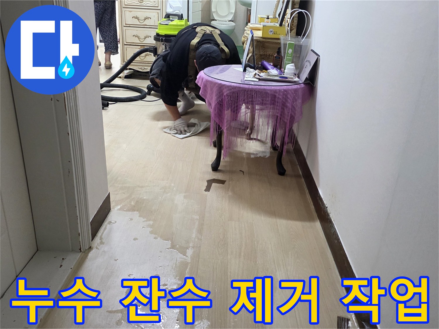 배관 주변 바닥에 고인 물을 흡입하여 정리하는 작업 현장입니다.