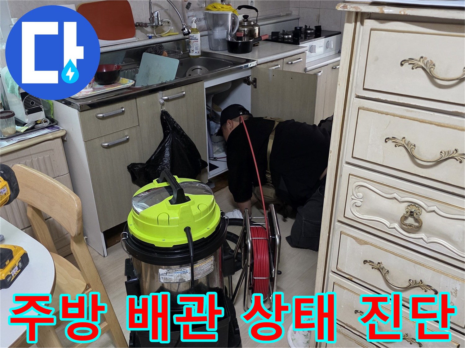 싱크대 아래 배관 연결 부위의 결함을 확인하는 엔지니어의 손길