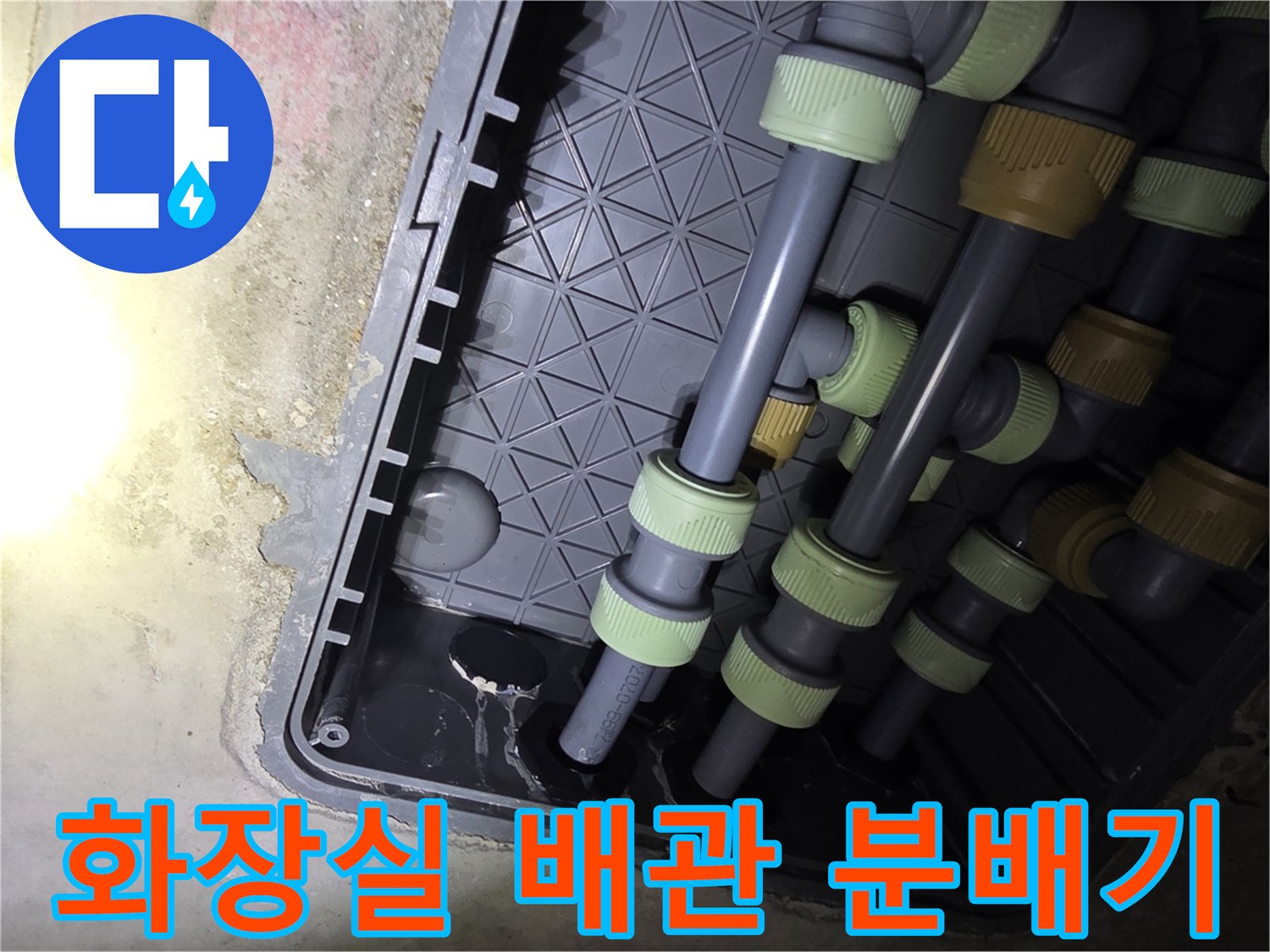 화장실 내부의 회색 PP-R 배관과 연결 부속들이 모여 있는 분배기 함 모습입니다.