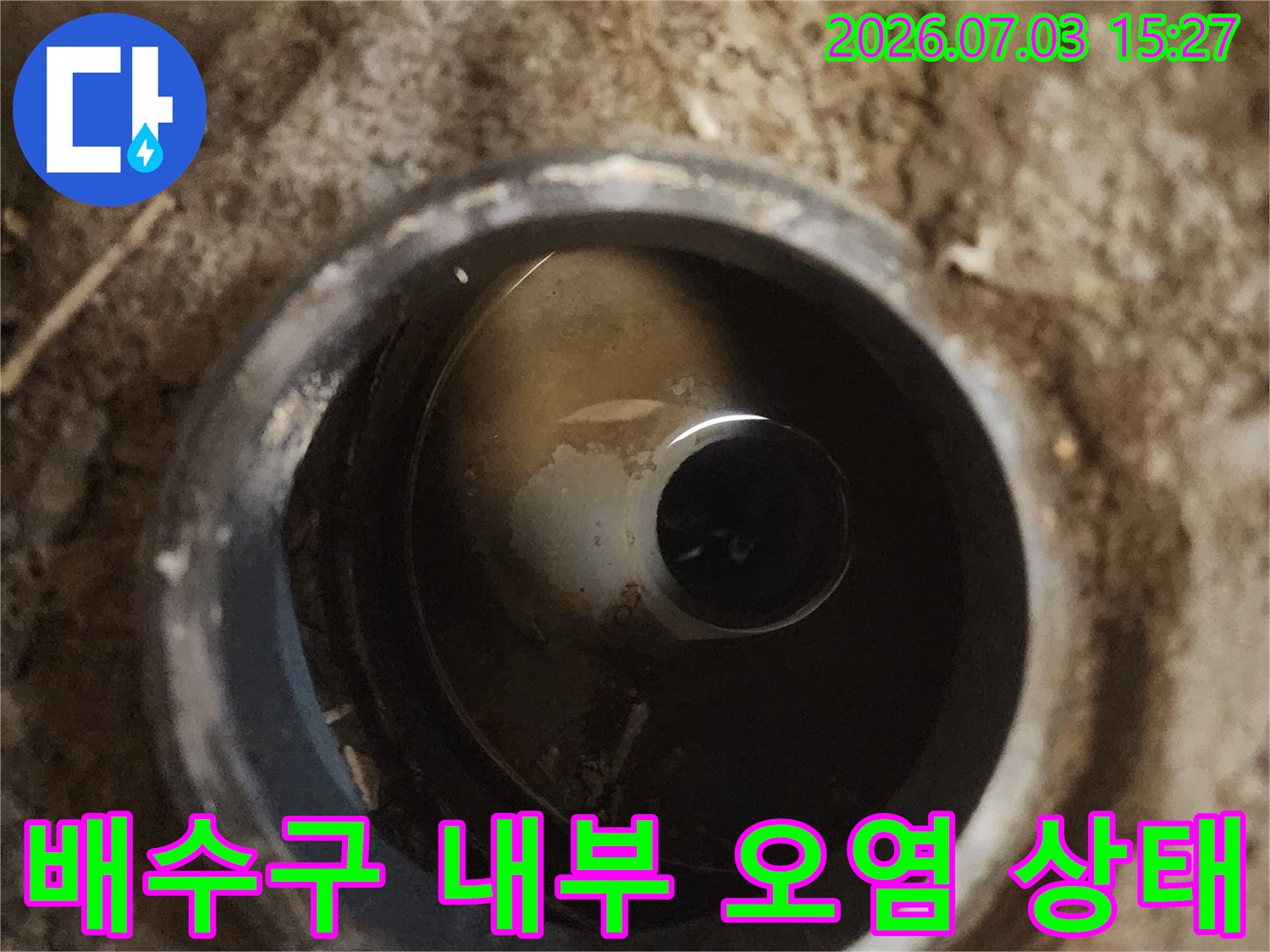 배수관 주변에 섞인 흙과 이물질이 보이는 배출부 모습