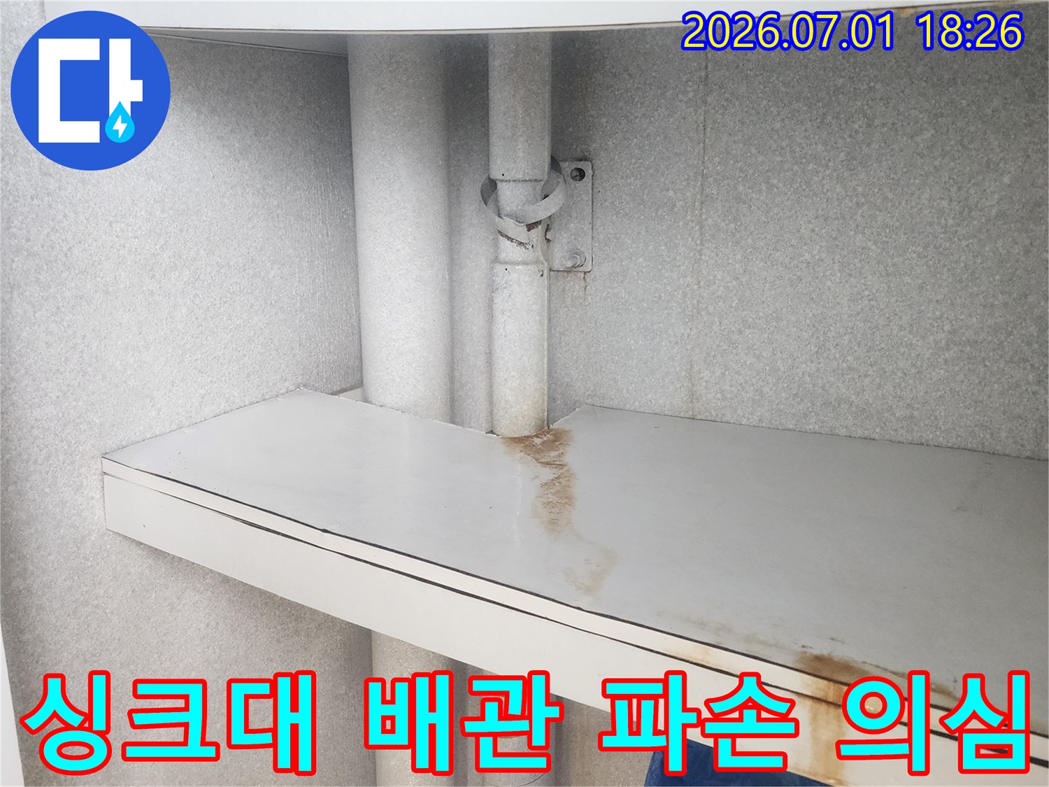 이 이미지는-싱크대 하부-배관 주변-가구 패널에-나타난-물 자국을 통해-배관 파손이-의심되는-현장을 보여줍니다