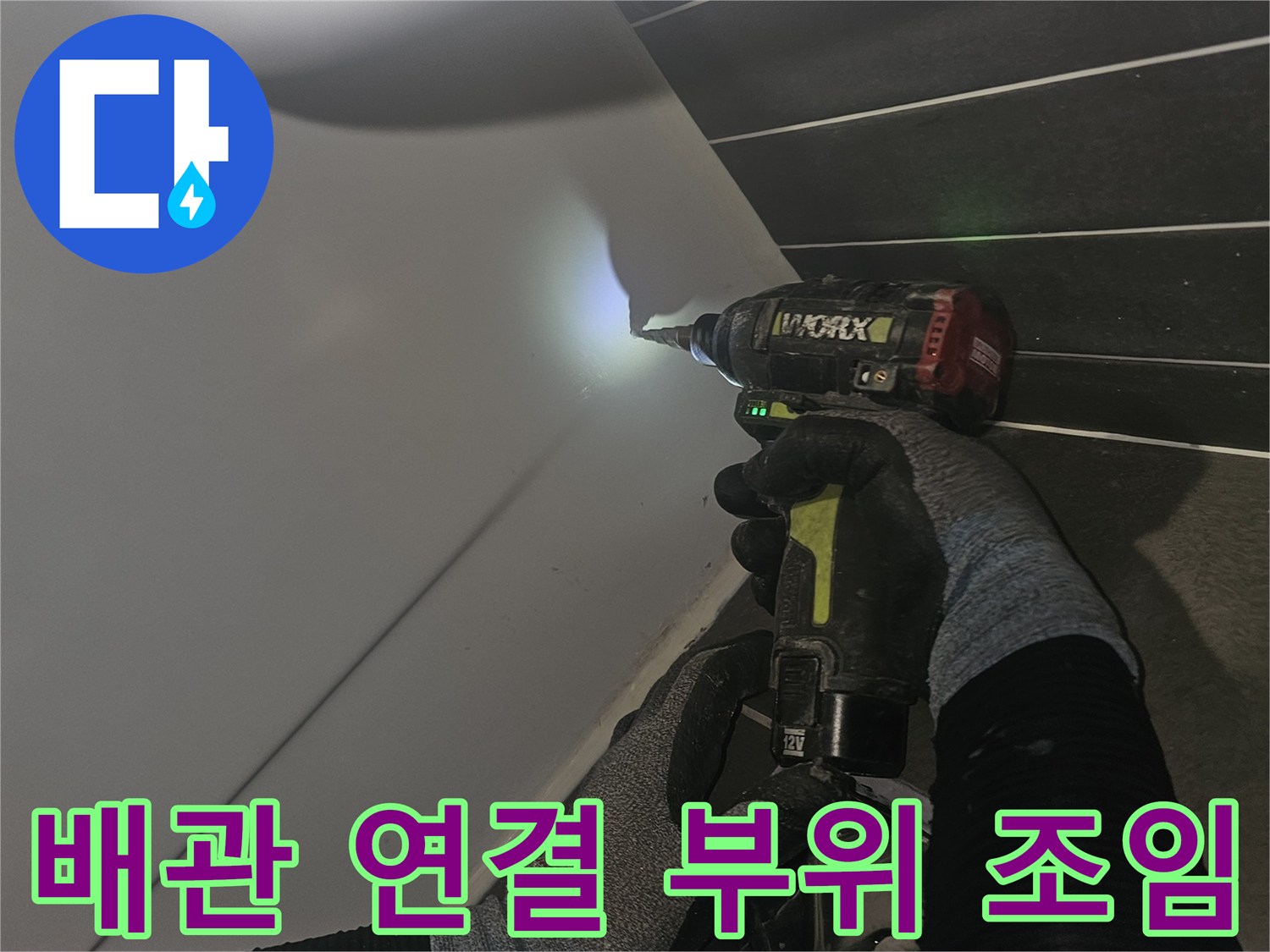 작업자가 전동 공구로-배수구 하부 배관을 고정하는 중