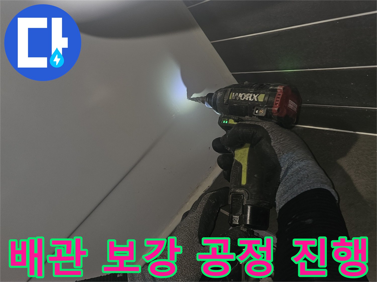 전동 드릴을 이용해 배관 연결 부위를 정밀하게 작업하는 장면입니다.