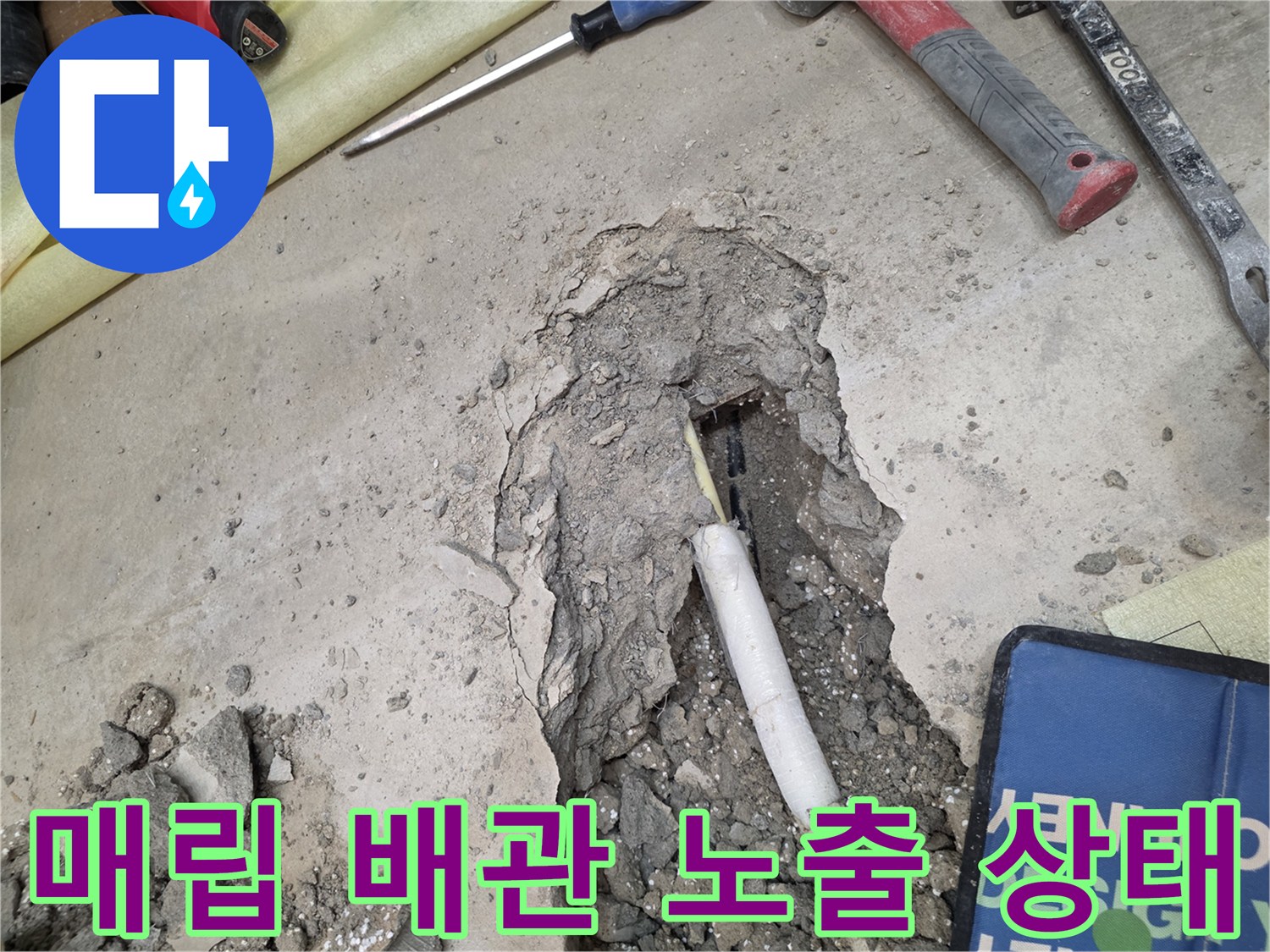 바닥 굴착을 통해 드러난 하얀색 매립 배관의 모습