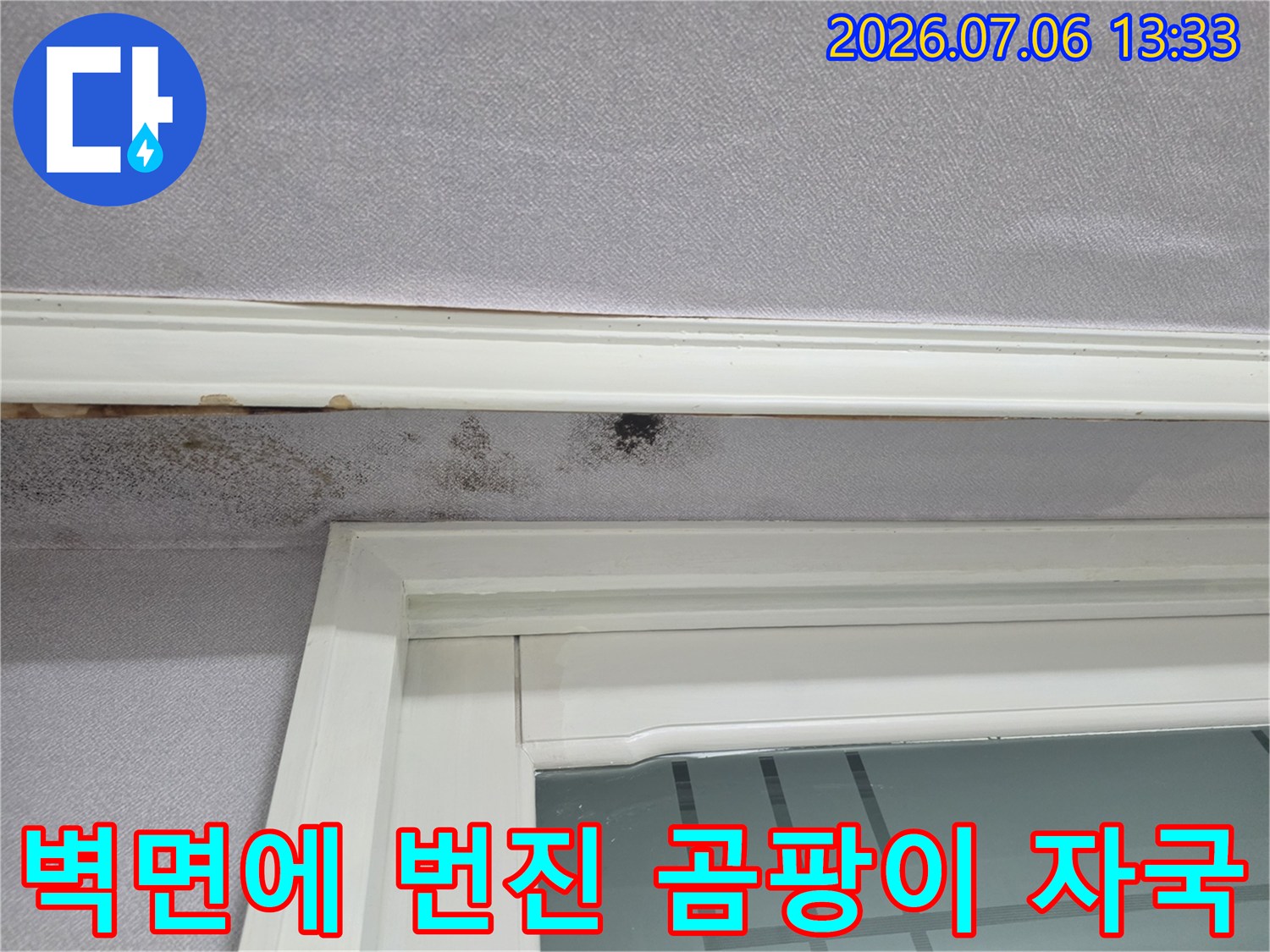 창문 틀 아래 벽지에 발생한 검은색 누수 오염