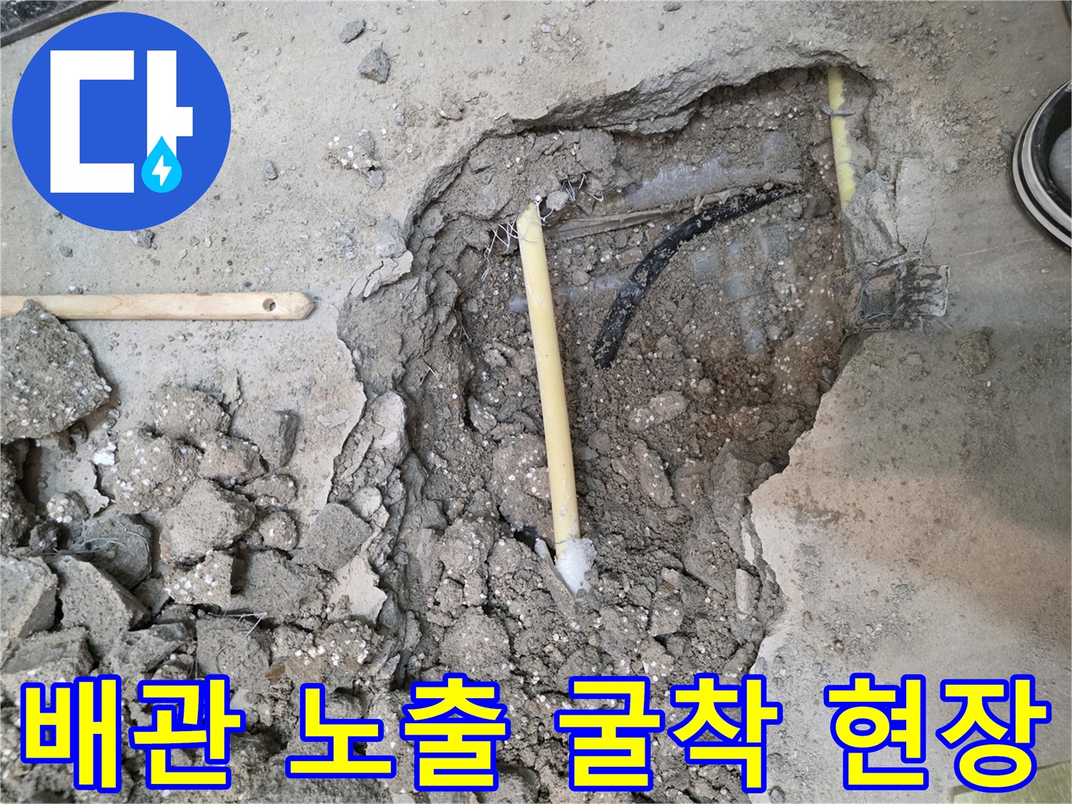 콘크리트 바닥을 굴착하여 드러난 배관 상태 사진입니다.