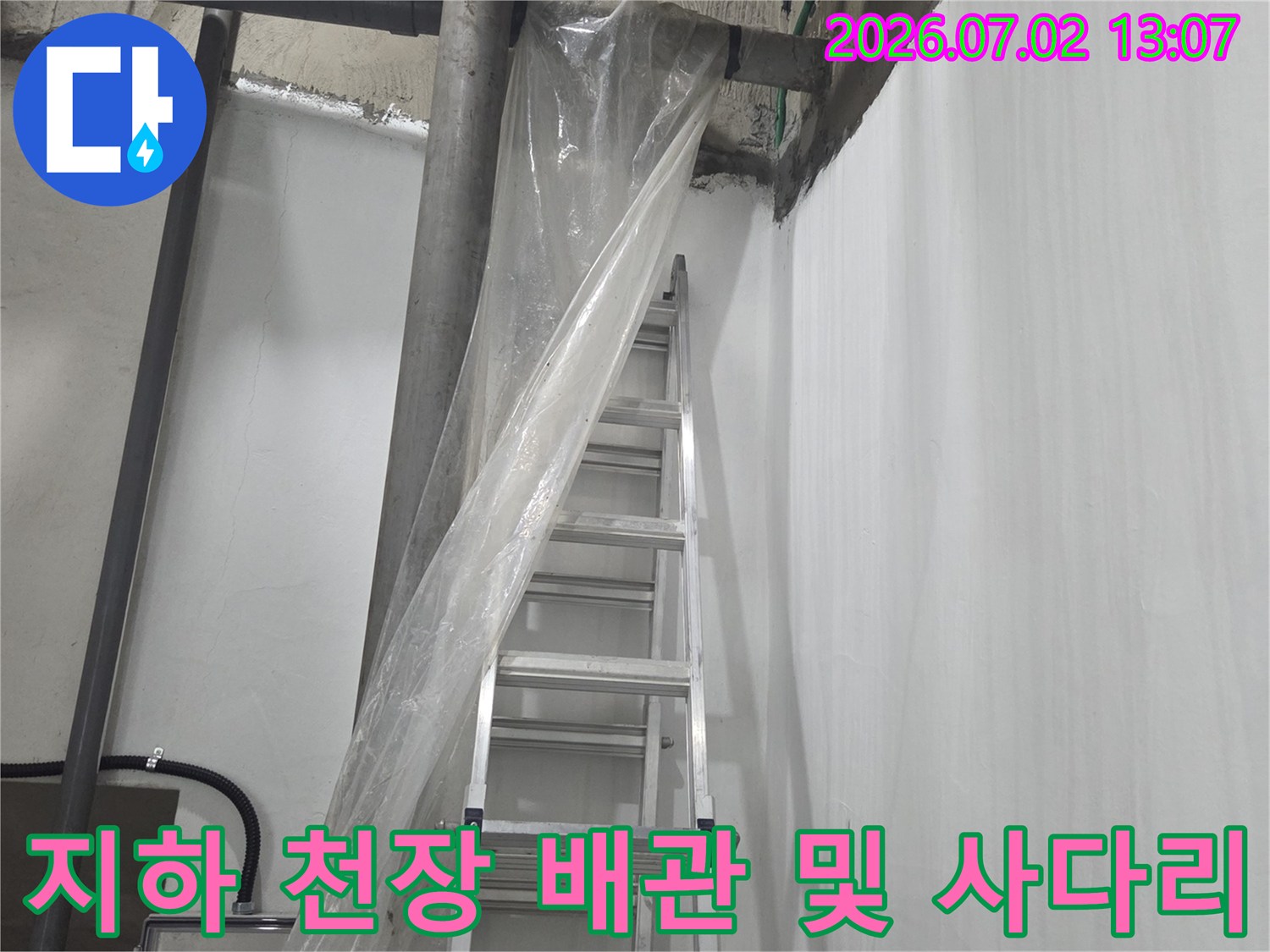 지하 공간-천장에 설치된 복잡한 배관 라인과 점검을 위해 놓인 알루미늄 사다리 모습