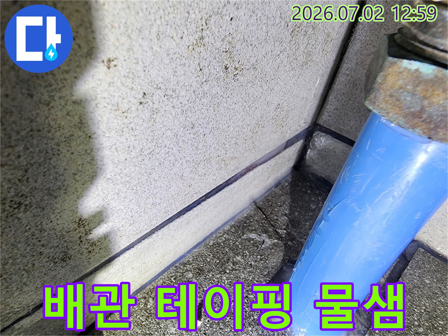 파란색-배관의-테이핑-주변에서-발견된-물샘-현상을-누수-전문가가-점검하는-모습을-담은-사진