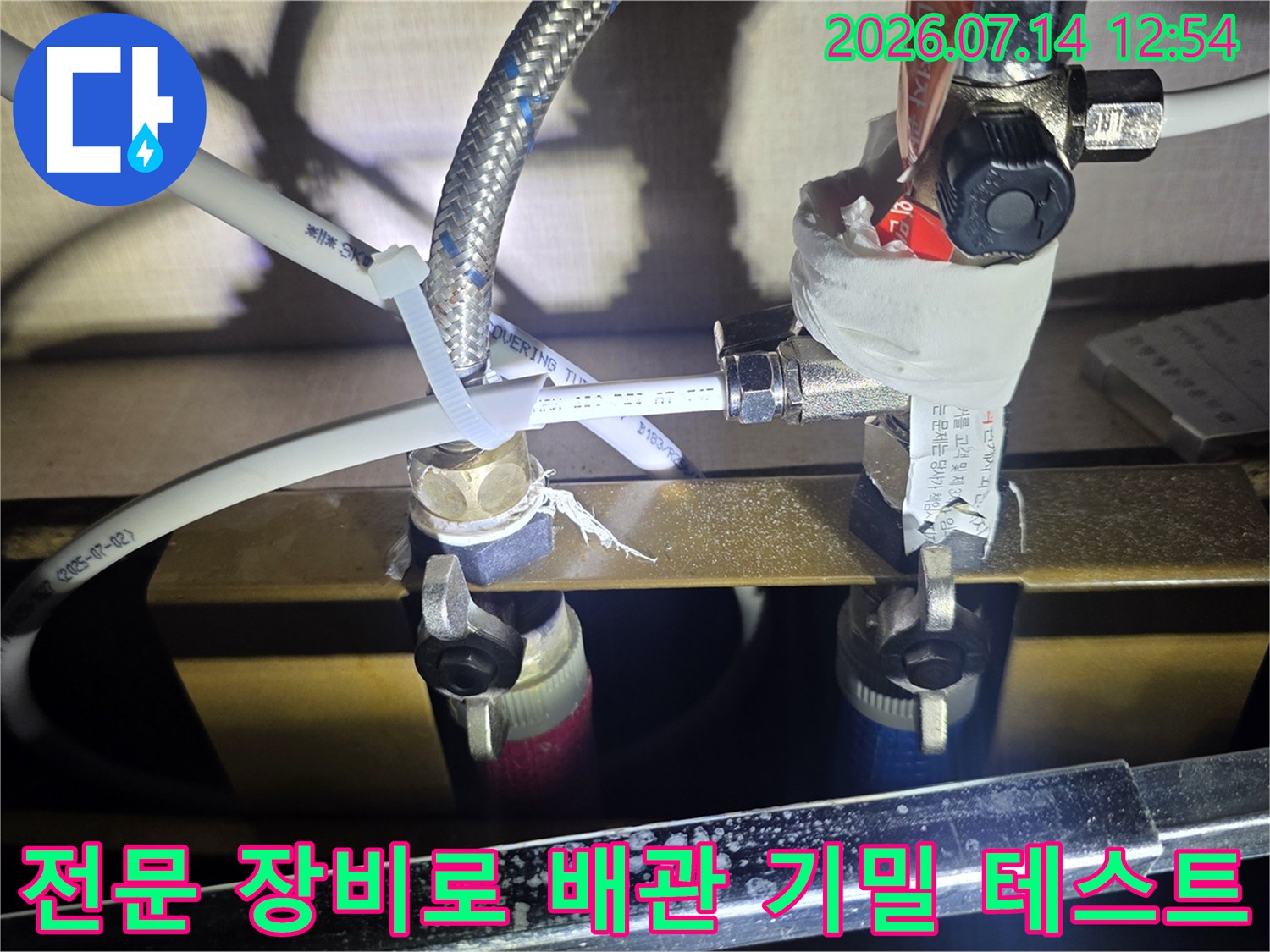 두 종류의 압력 게이지를 활용하여 싱크대 하부 배관의 누수 유무를 정밀하게 검사하는 모습
