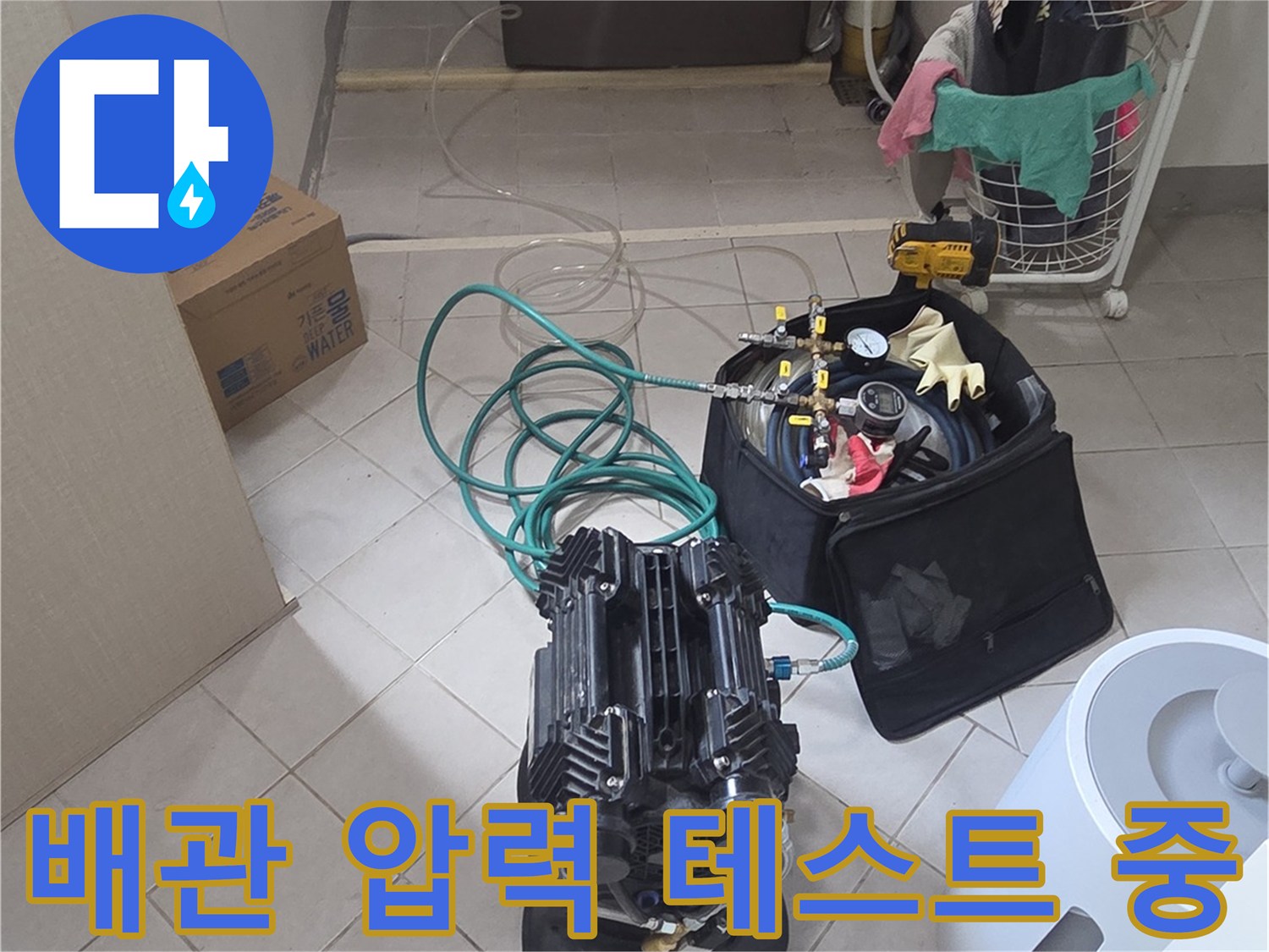 압력 게이지와 연결 호스가 배치된 싱크대 하부 작업 환경