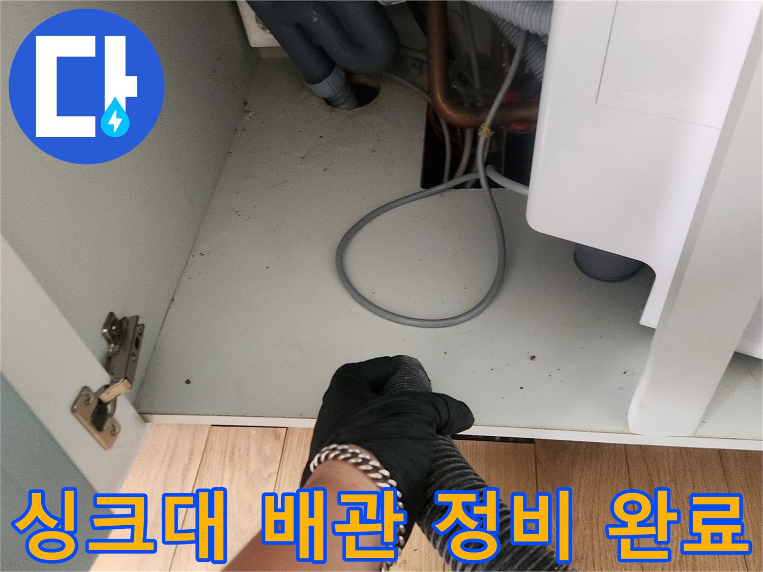 정리된 싱크대 하부장 내부와 새롭게 교체된 배관 호스