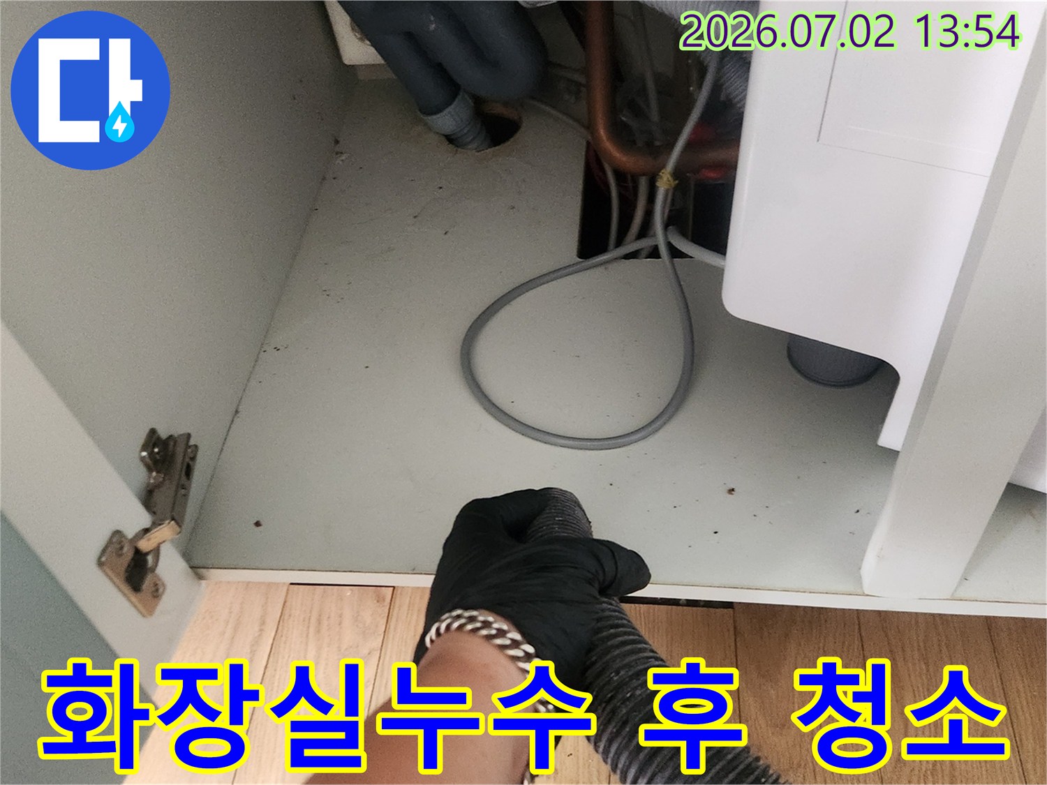 화장실 누수 공사 후-작업자가 석션 장비로-바닥의 물기와 오염물을 제거하는 모습