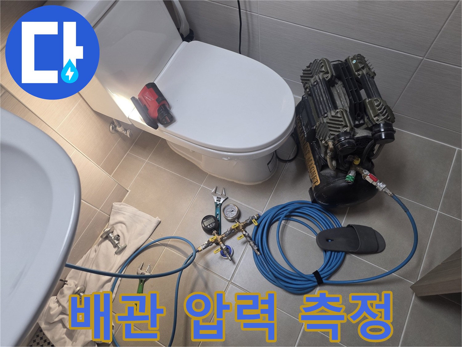 변기 옆에 놓인 수압 측정 게이지와 연결된 에어 호스