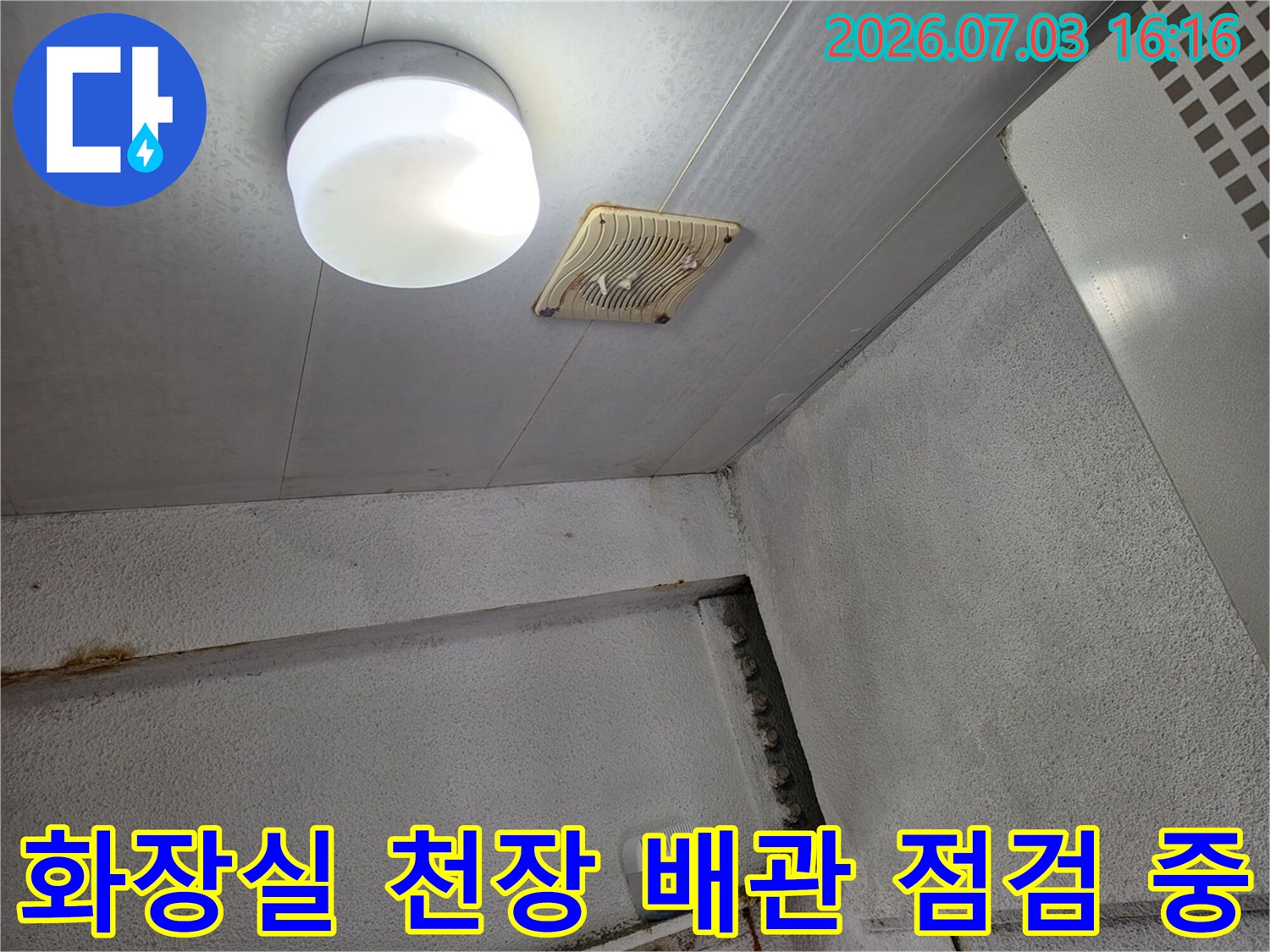 상가 화장실 천장의 환풍기 및 조명 주변 배관을 점검하는 장면
