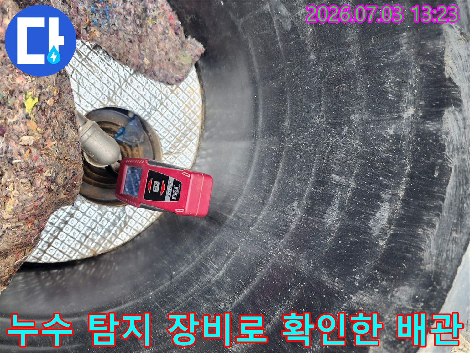 붉은색 누수 탐지기 장비를 활용해 파손된 배관 부위를 정밀 점검하는 모습