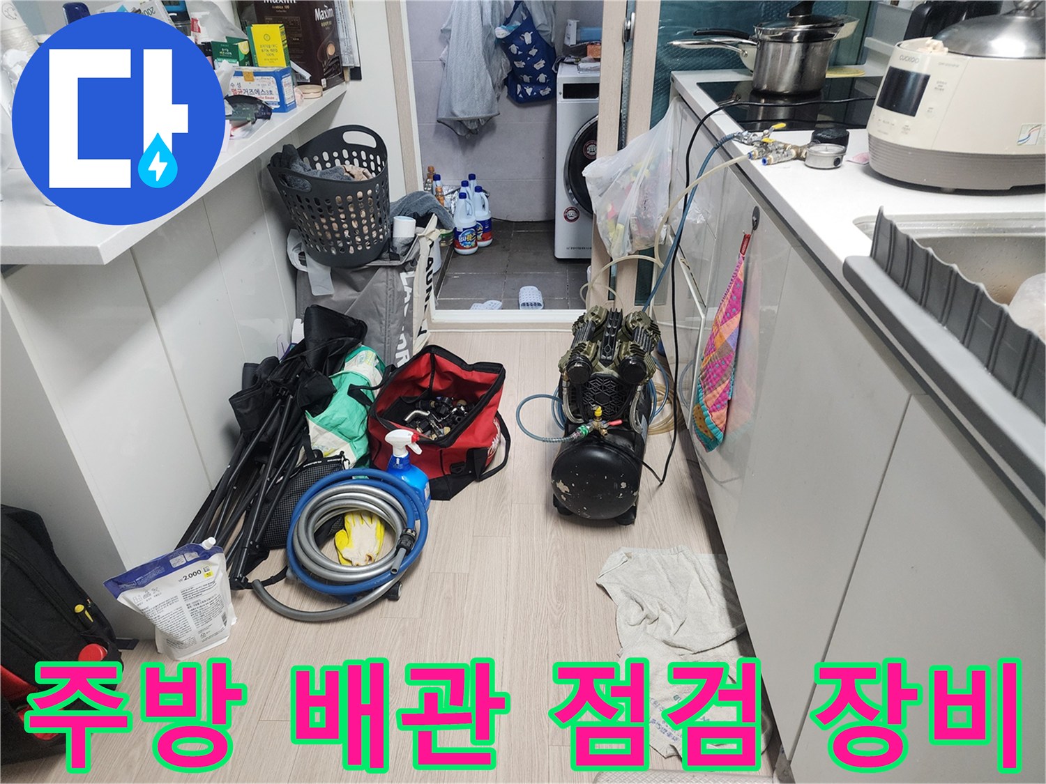 주방 바닥에 놓인 누수 탐지를 위한 압력계와 각종 배관 보수 자재들