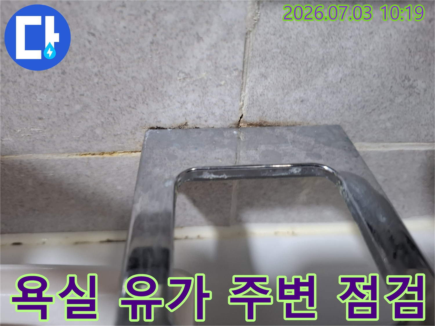 화장실 바닥 배수구 주변의 타일 및 프레임 접합 부위를 촬영한 사진