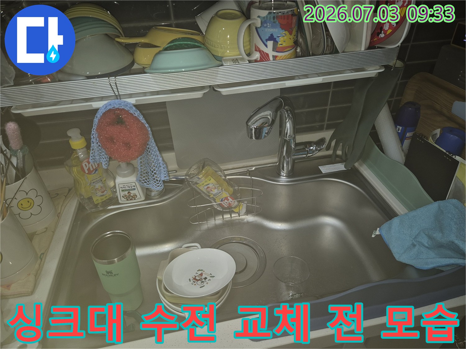 기존에 설치된 노후된 주방 싱크대 수전과 세척 용품이 놓여 있는 상태
