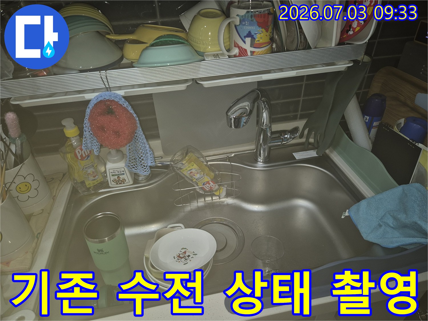 싱크대 내부에 비치된 세척도구와 노후한 수도꼭지