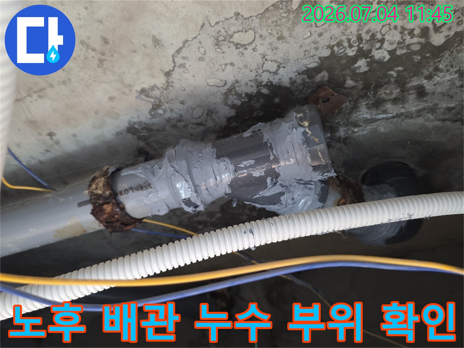 습기 흔적이 남은 천장 속 노출 배관의 연결부를 조사하는 현장 사진