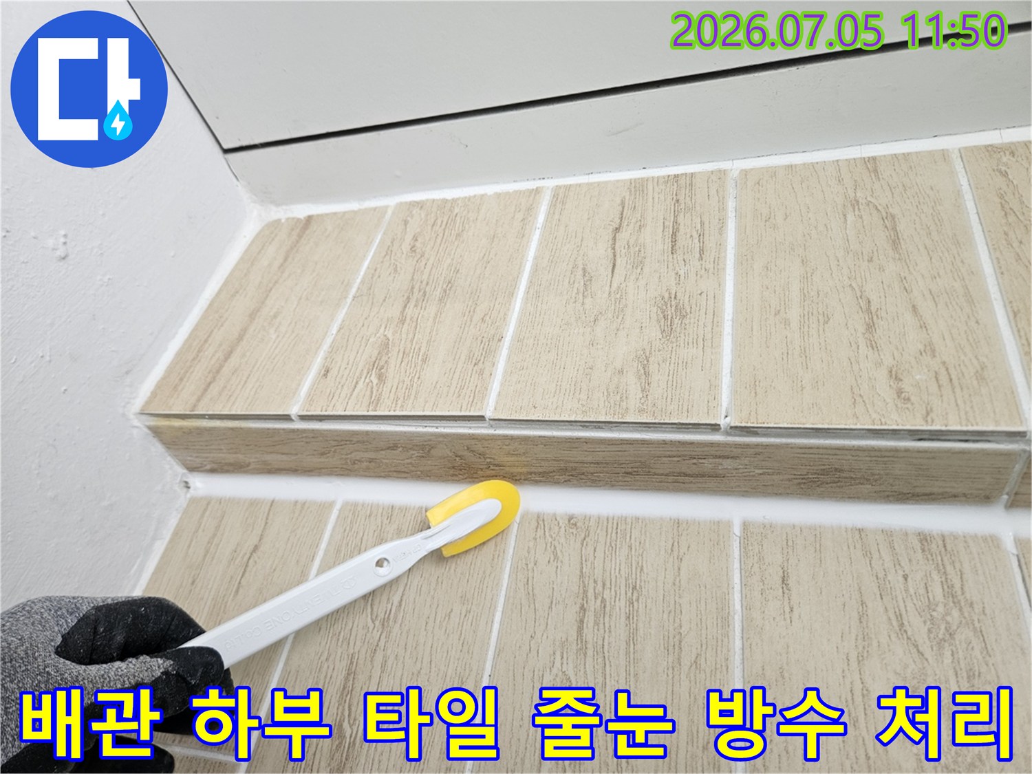 흰색 방수 실란트로 마감된 배관 주변 타일 면