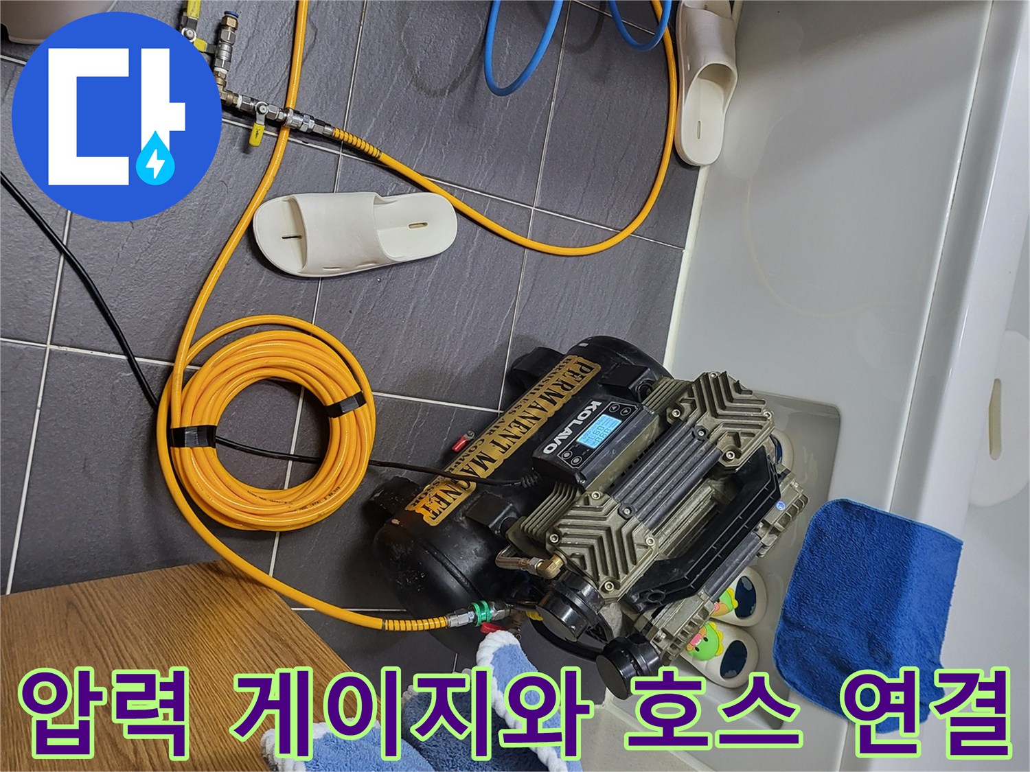 바닥 타일 위에 놓인-배관 검사용 압력계와 컴프레셔