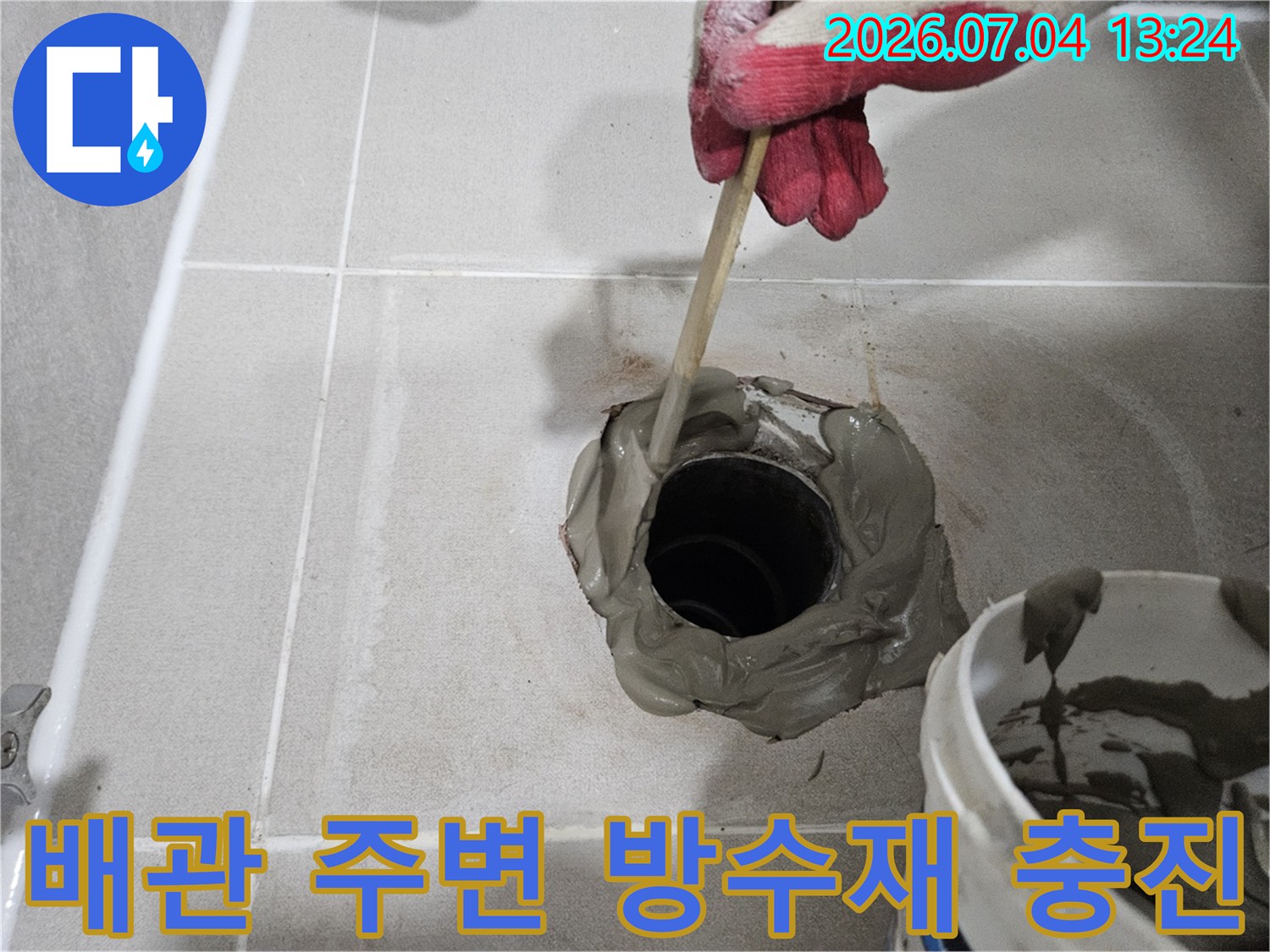 회색 방수재로 배관 주변을 채우는 현장 모습