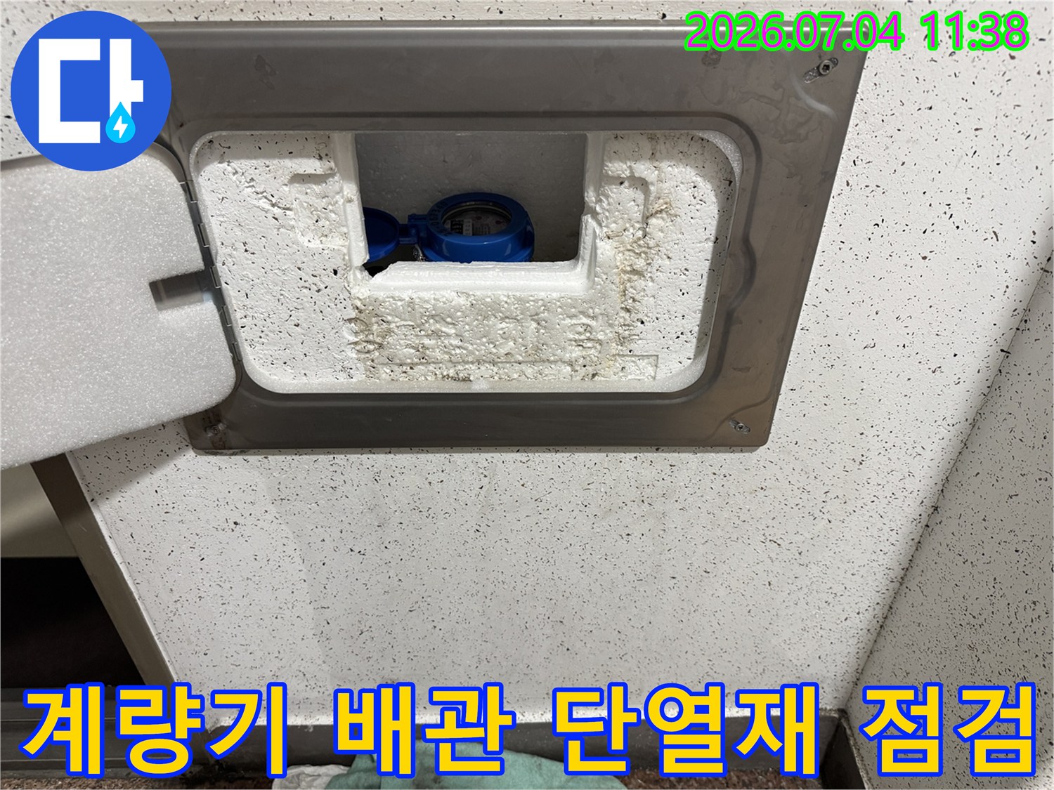흰색 단열재와 파란 계량기가 노출된 계량기함 내부 모습
