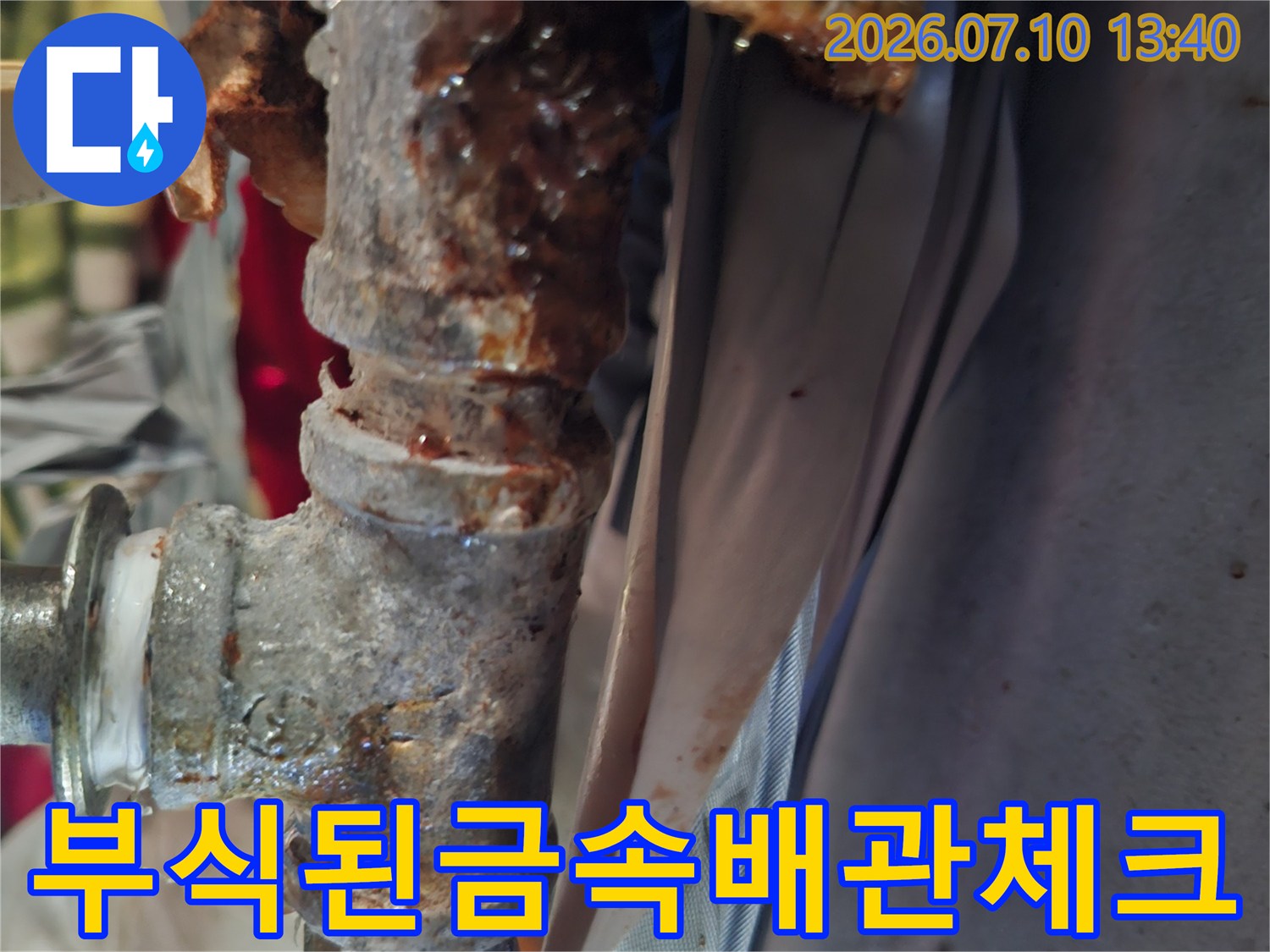 심하게 부식되어 찌꺼기가 고착된 금속 배관 연결 부위의 모습