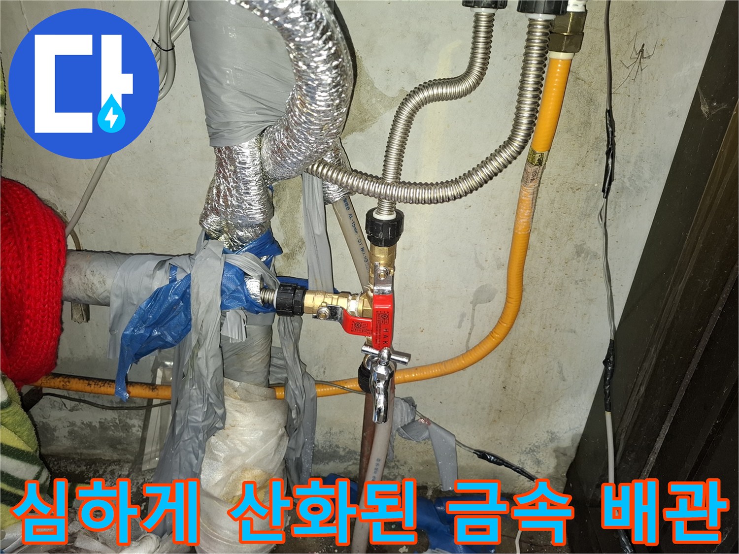 은색 주름관과 붉은 밸브가 연결된 노후 배관 설비